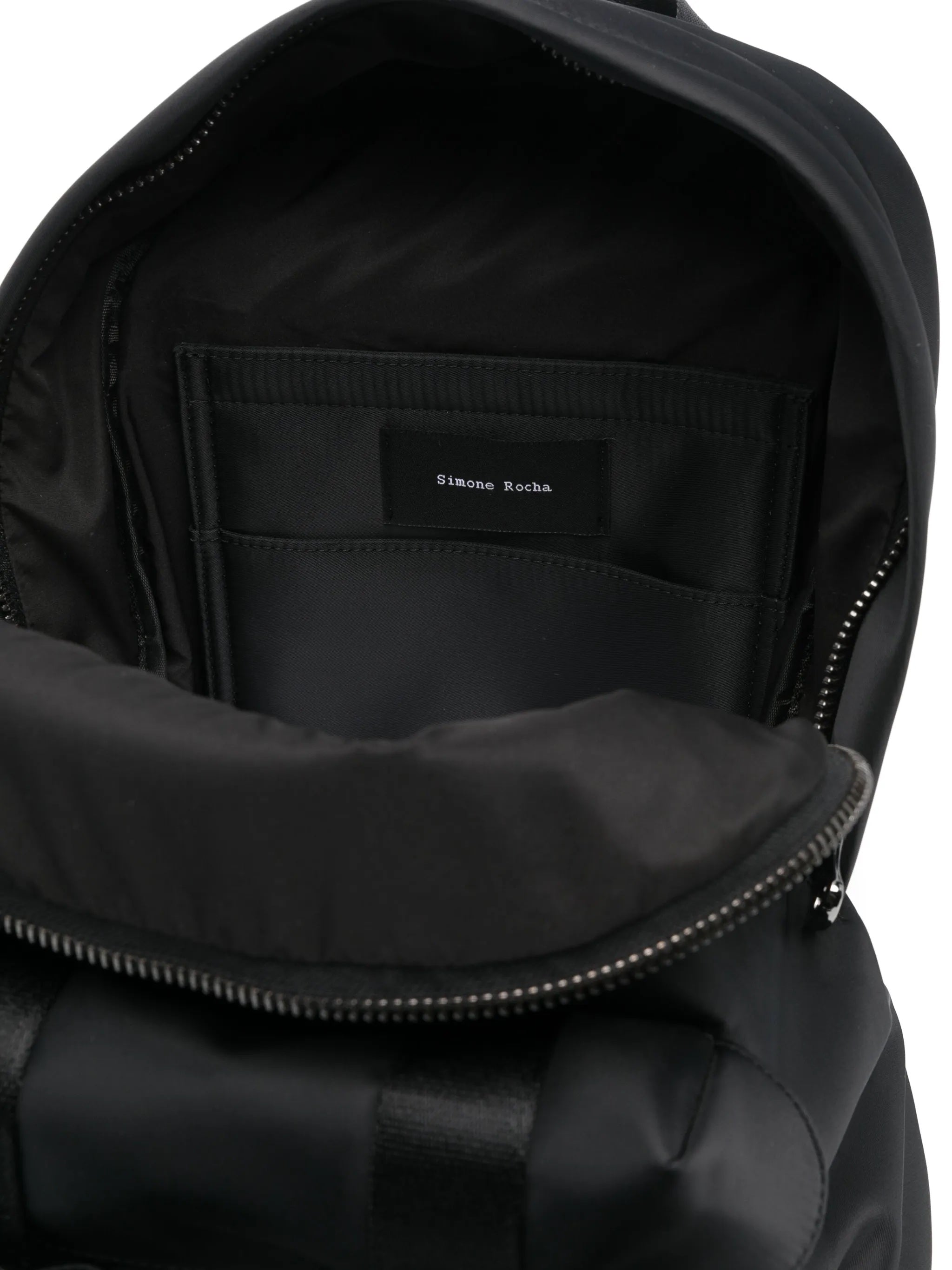 Close-up of a black backpack with a visible brand label on a white background