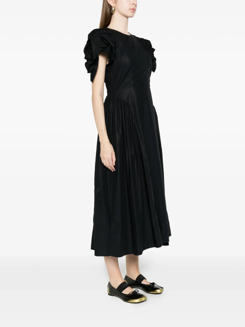 Side view of the model wearing the Rose Puff Sleeve Hip Dress, highlighting the exaggerated hip detail and sculptural volume.