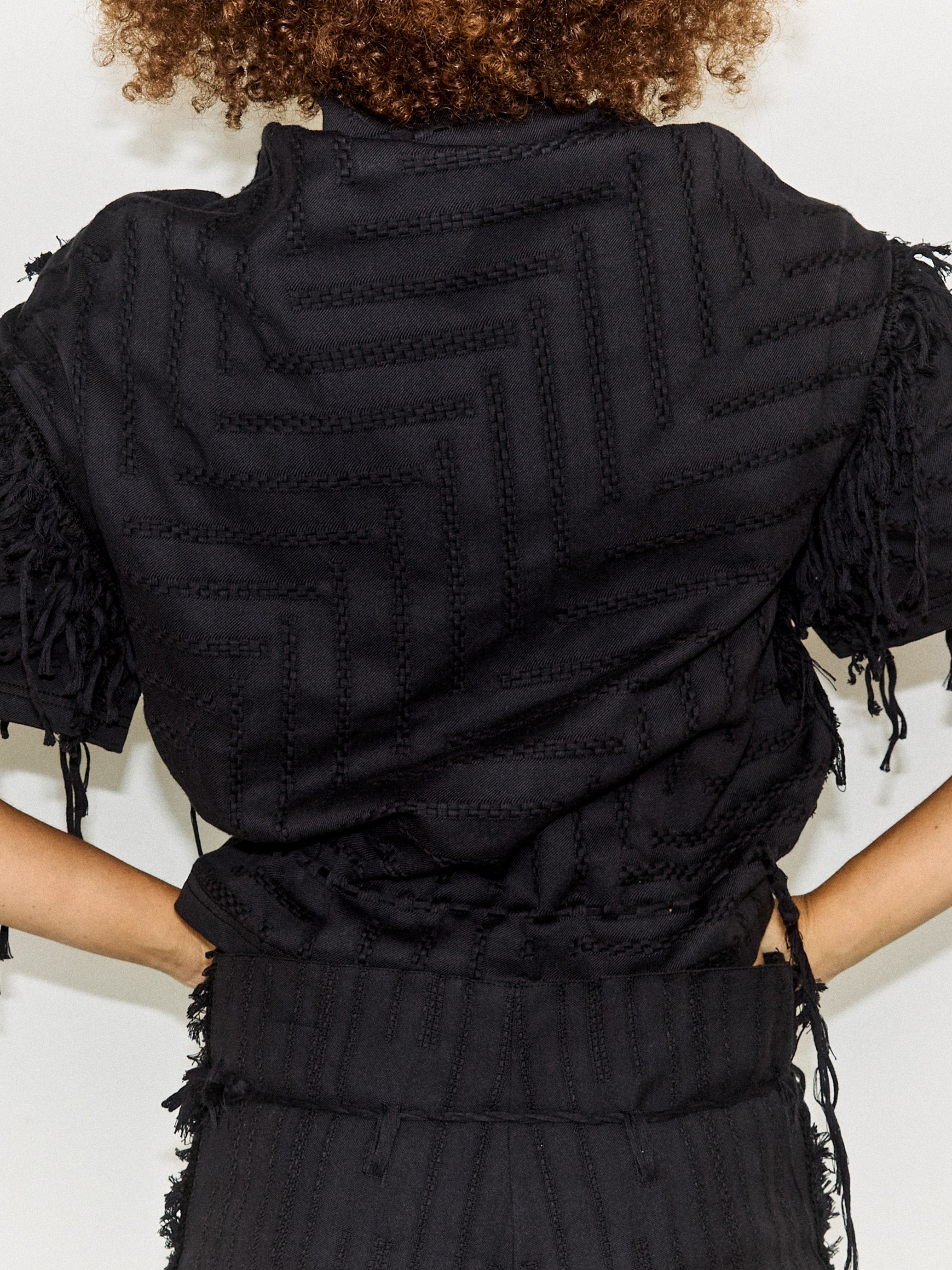 Model wearing the Stem Basket Tee in black, back view, close-up