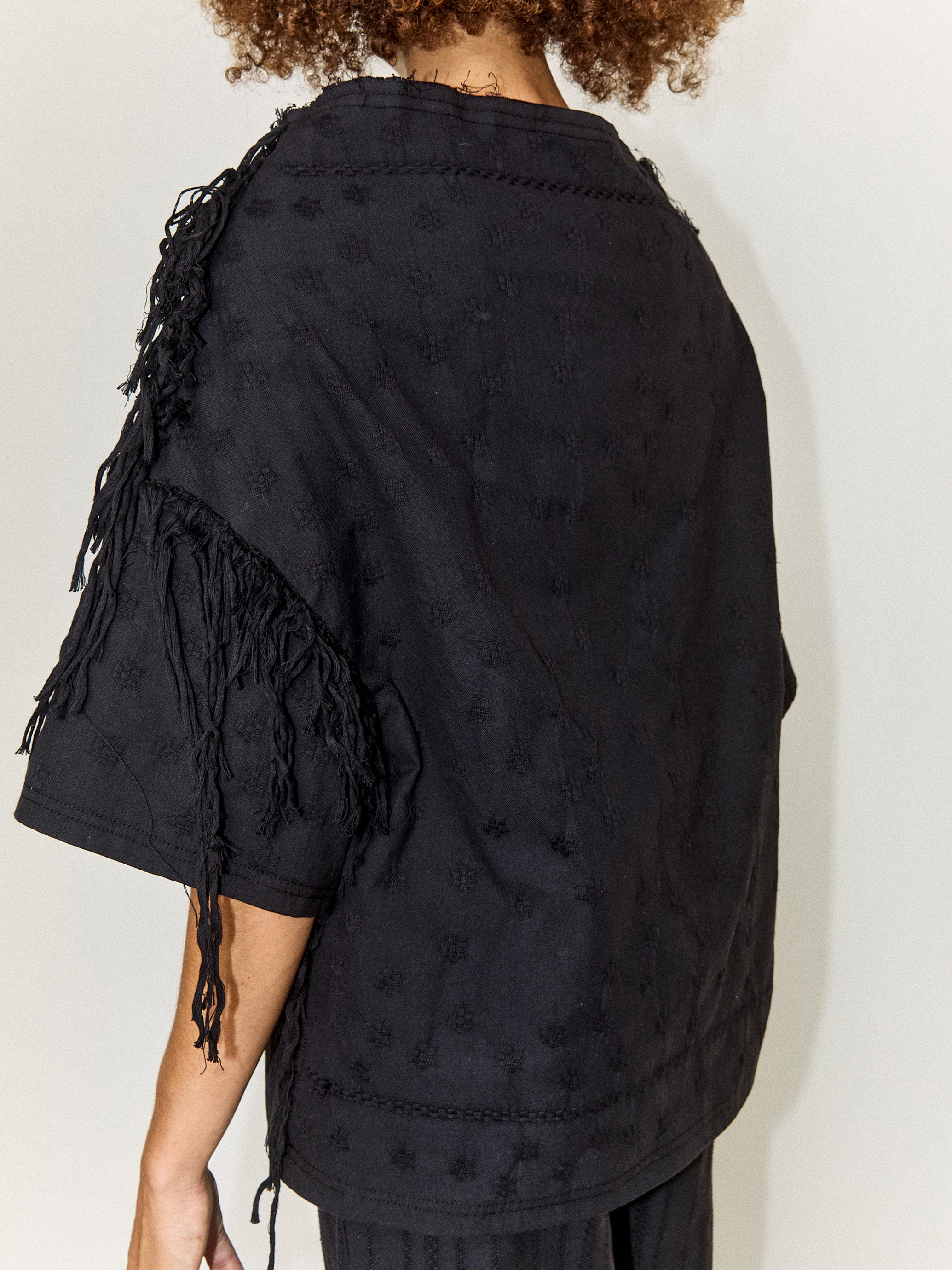 Model wearing the Stem Flower Tee in black, back view, close-up