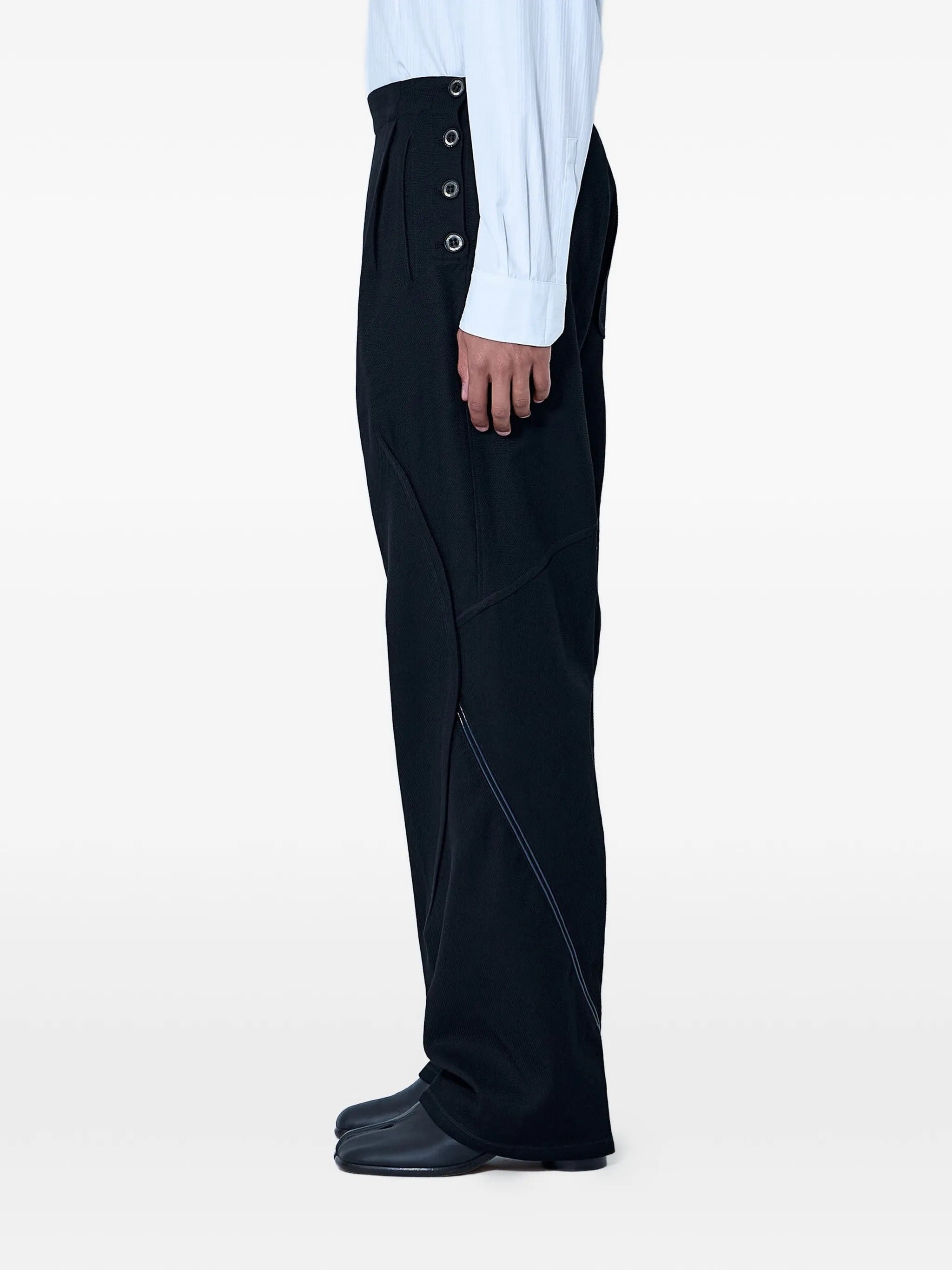 Side view of the model wearing the Kiko Kostadinov Vig K-Dart Trouser in Space Black.