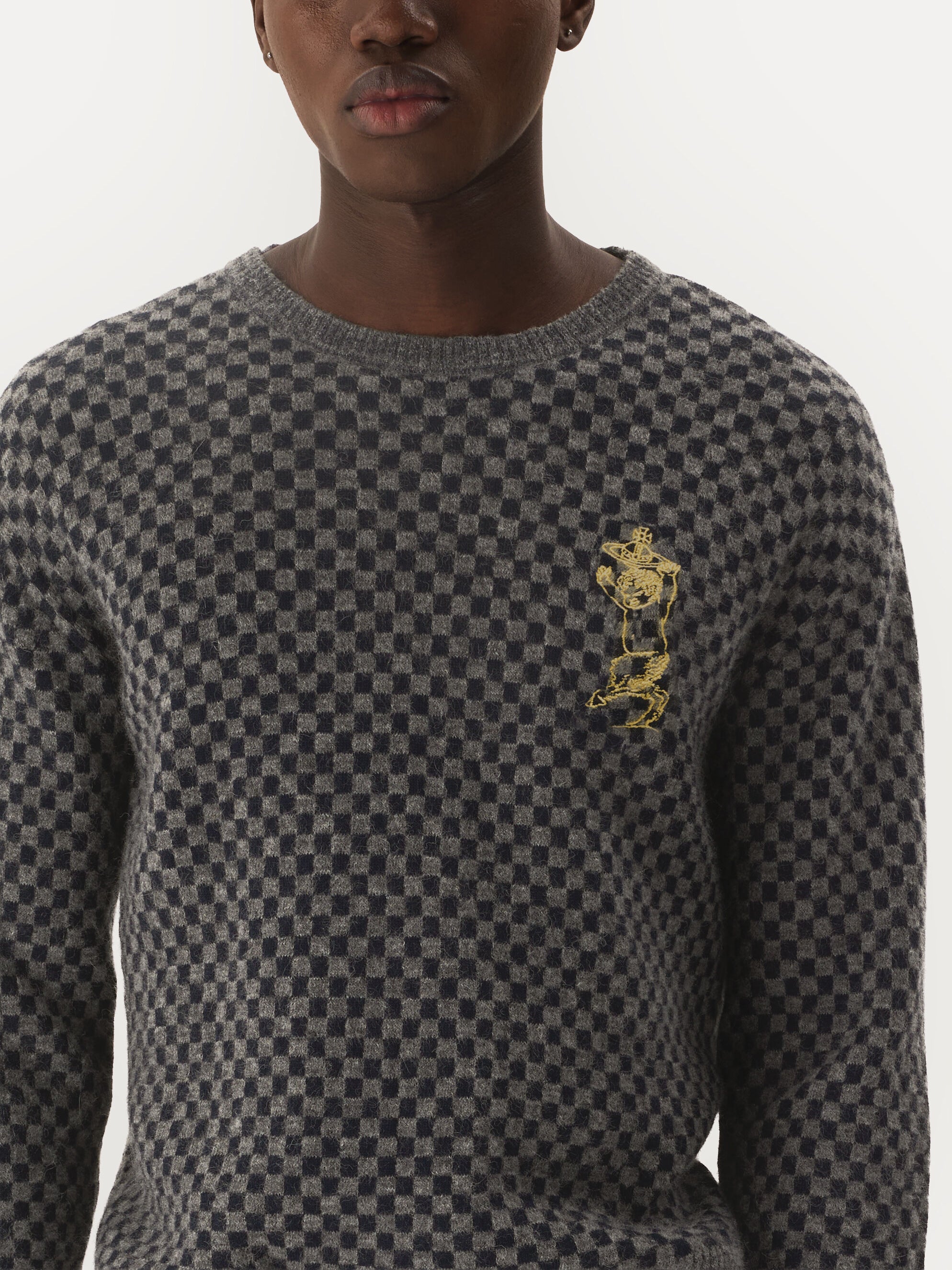 Close-up of Vivienne Westwood Checkmate Jumper showing grey navy checkerboard knit texture and embroidered dancing satyr motif