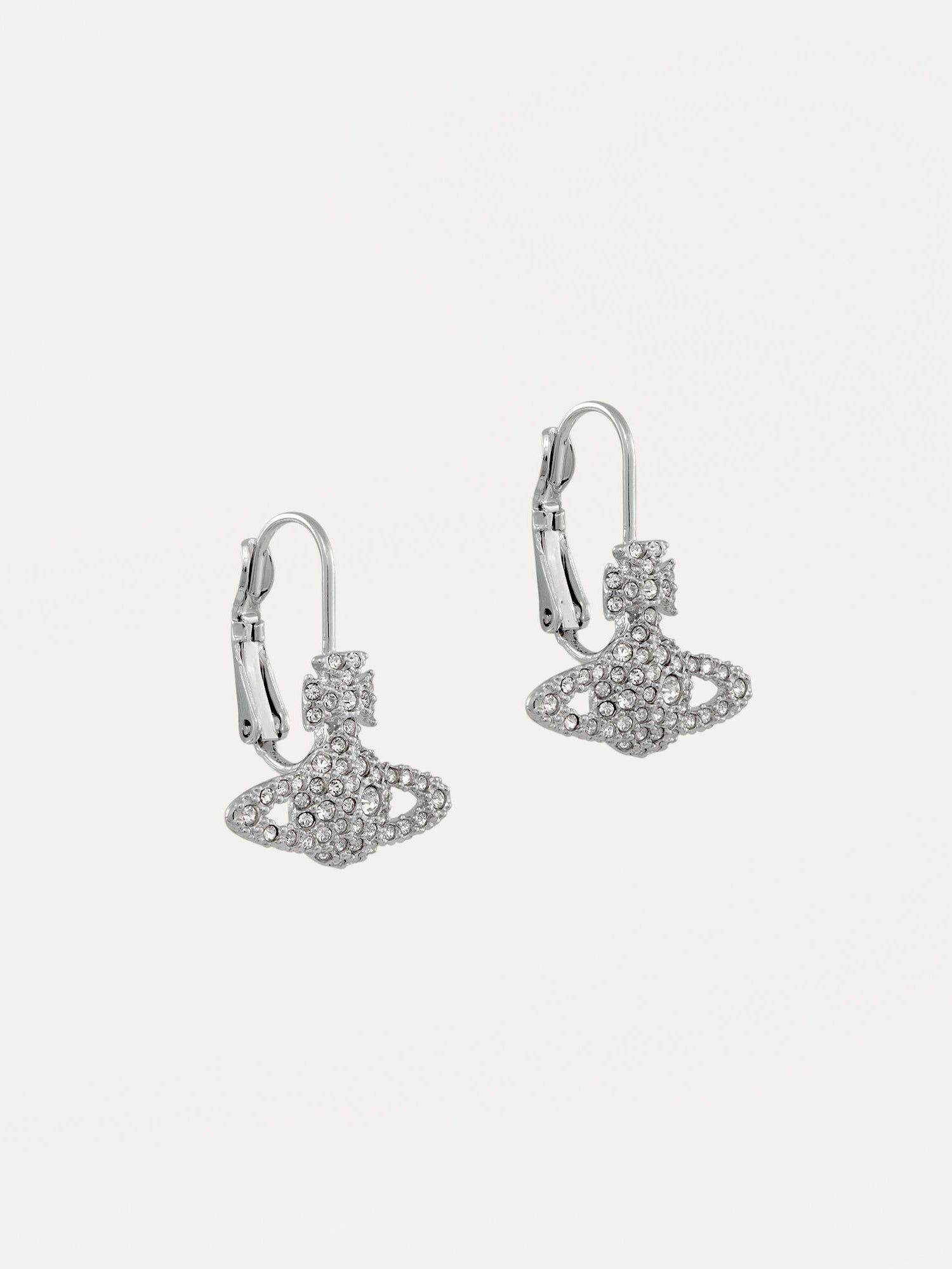Angled view of Vivienne Westwood Grace Bas Relief Earrings in platinum crystal showing polished silver-tone drops, crystal orb motifs and hinged backs