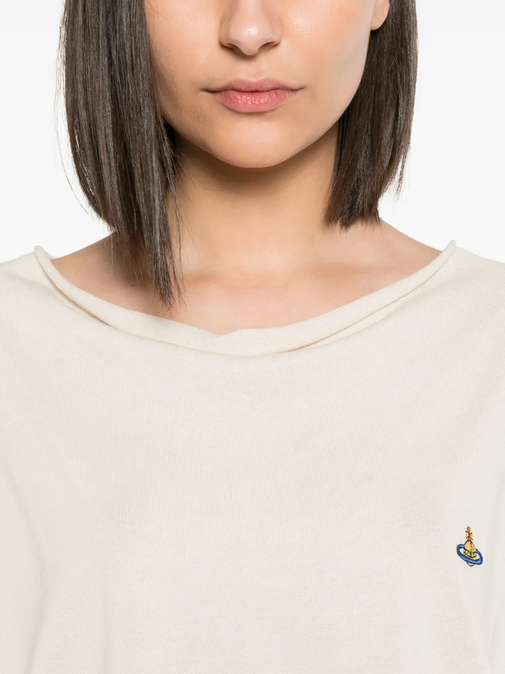 Model wearing Pamela Jumper in Cream by Vivienne Westwood, closeup of softly draped cowl neckline and multicolour Orb logo embroidery on cream cotton knit, Spring/Summer 2026
