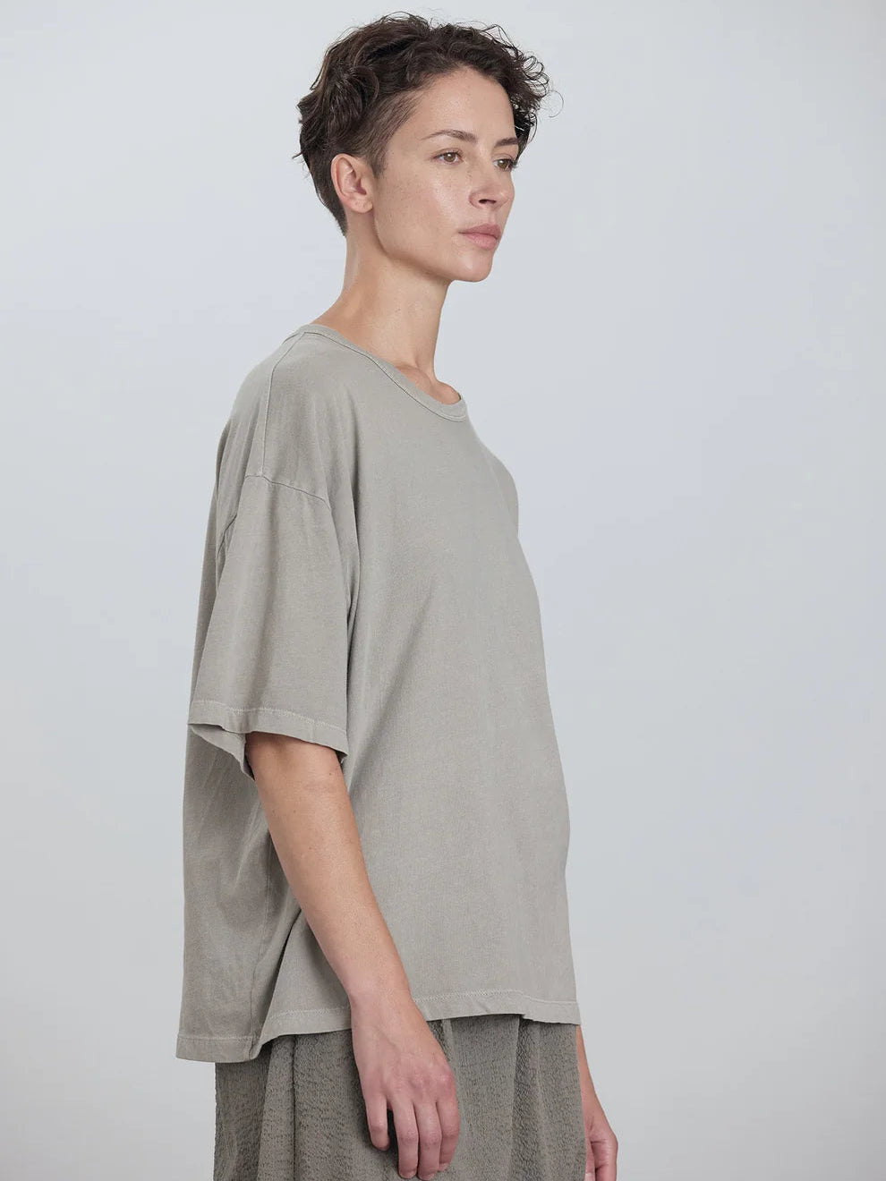 Black Crane Wide Short Sleeve Tee in Grey - three-quarter view on model showing dropped shoulder and relaxed fit