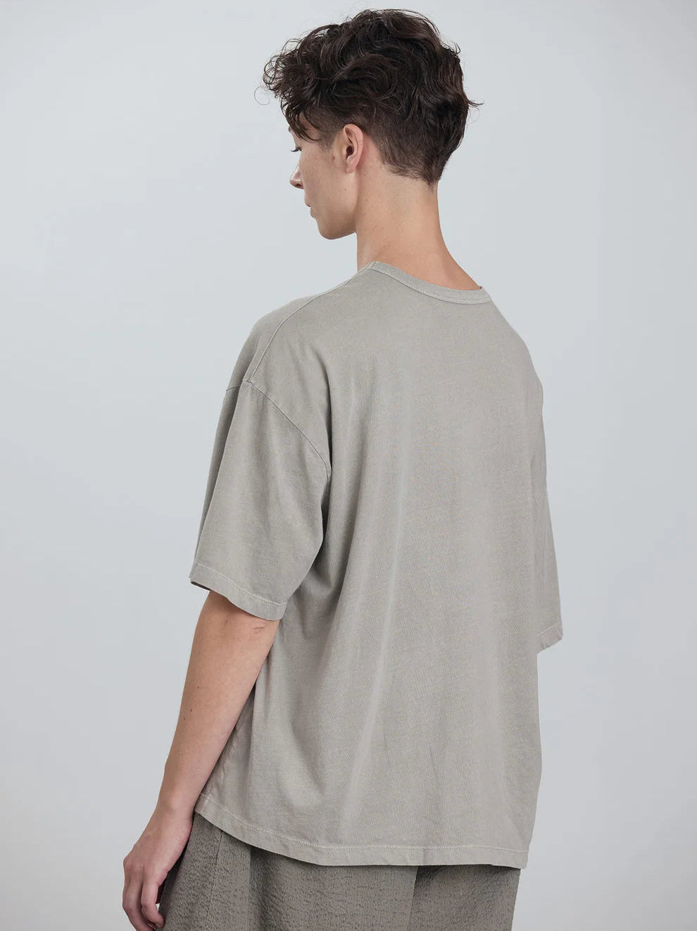 Black Crane Wide Short Sleeve Tee in Grey - back view on model showing dropped shoulder and boxy silhouette