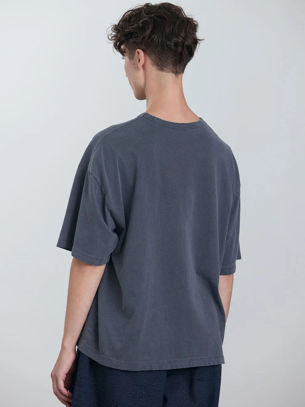 Black Crane Wide Short Sleeve Tee in Indigo - back view on model showing dropped shoulder and boxy silhouette