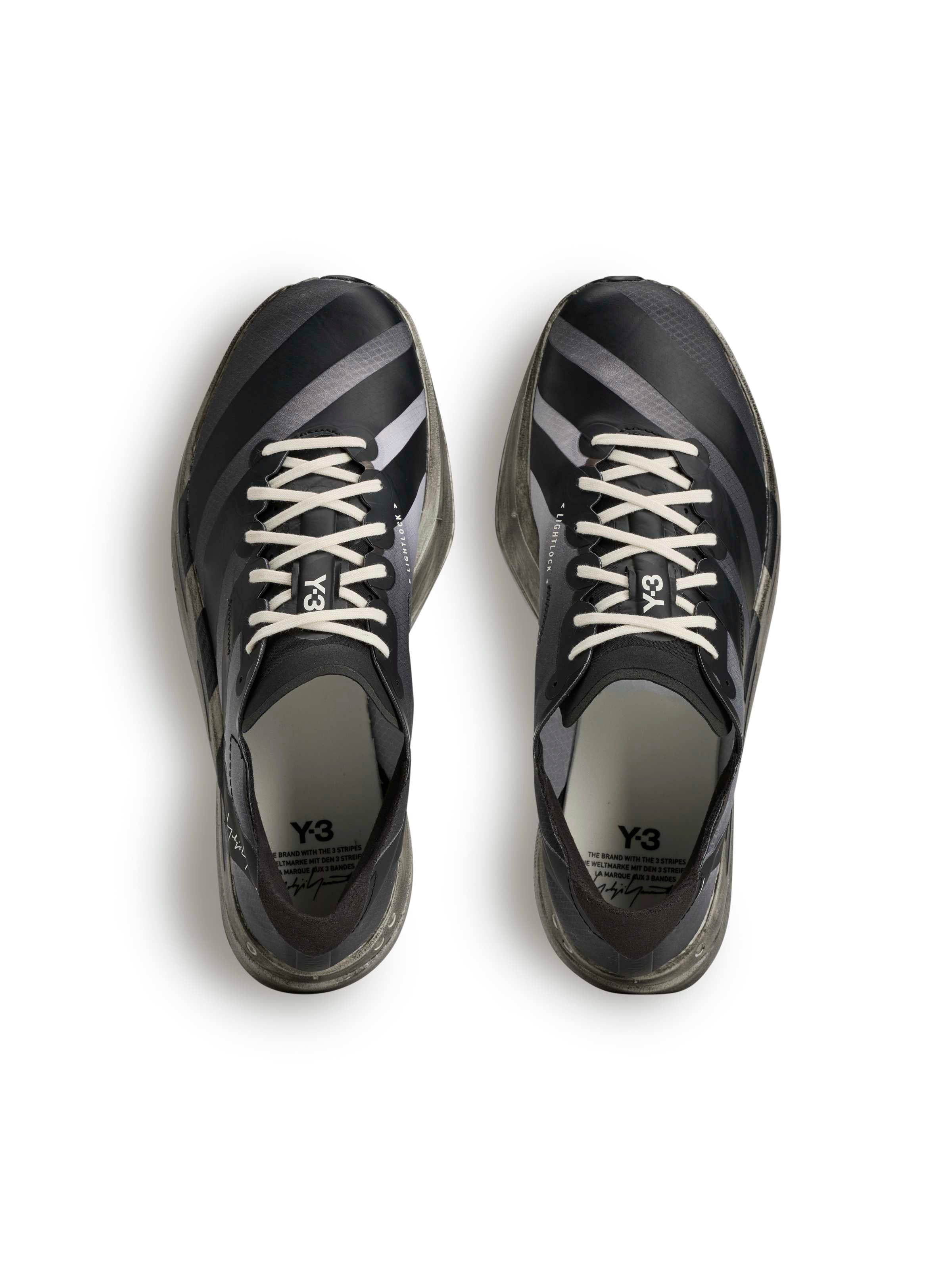 Y-3 Adios Pro 4 top-down pair view, black textile upper, Lightlock construction, off-white rope laces, tonal 3-Stripes, road racing silhouette