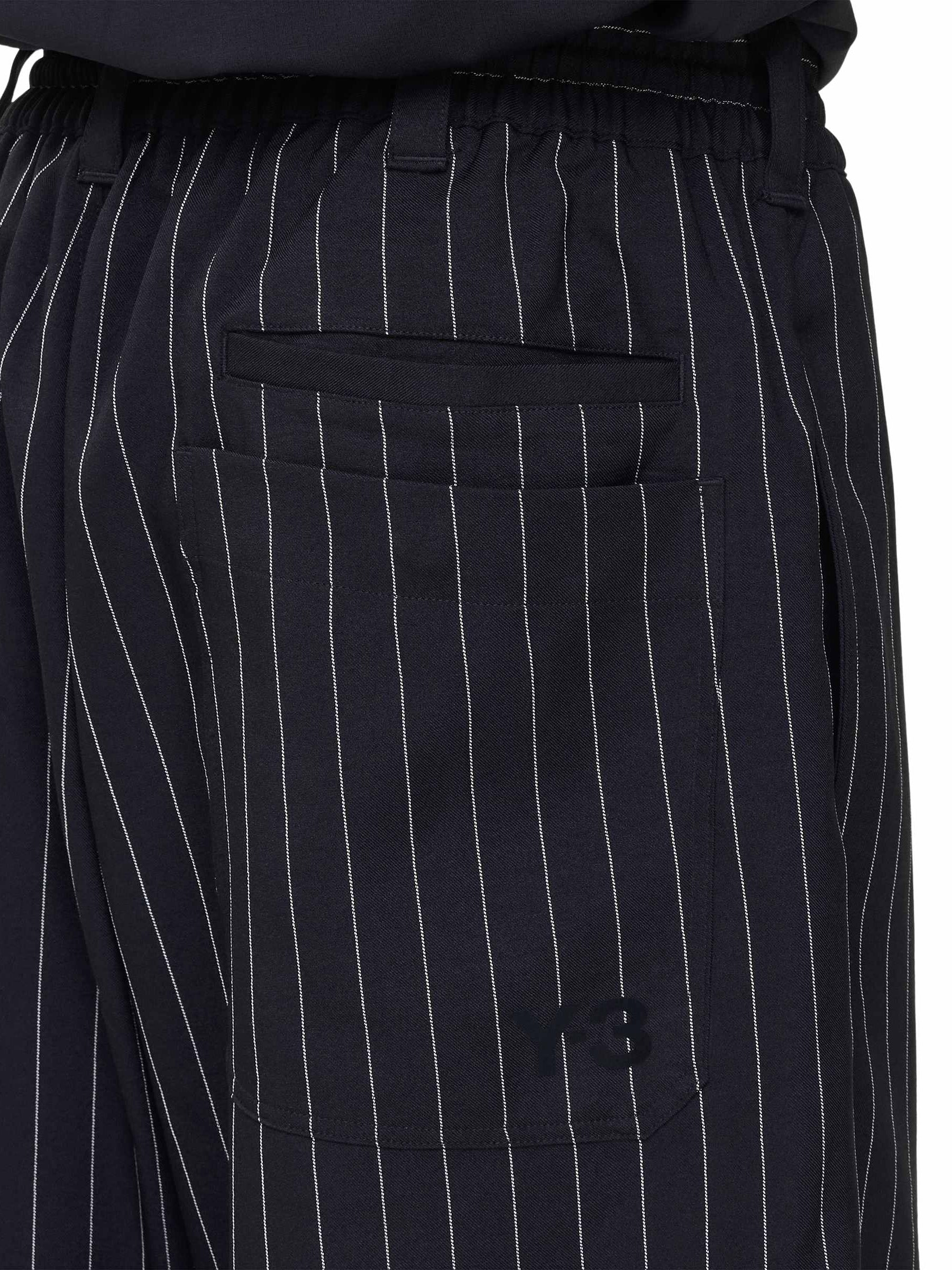 Close-up back view of a male model wearing the Y-3 Pinstripe Sport Uniform Shorts in Black, emphasizing the fabric texture and relaxed fit.