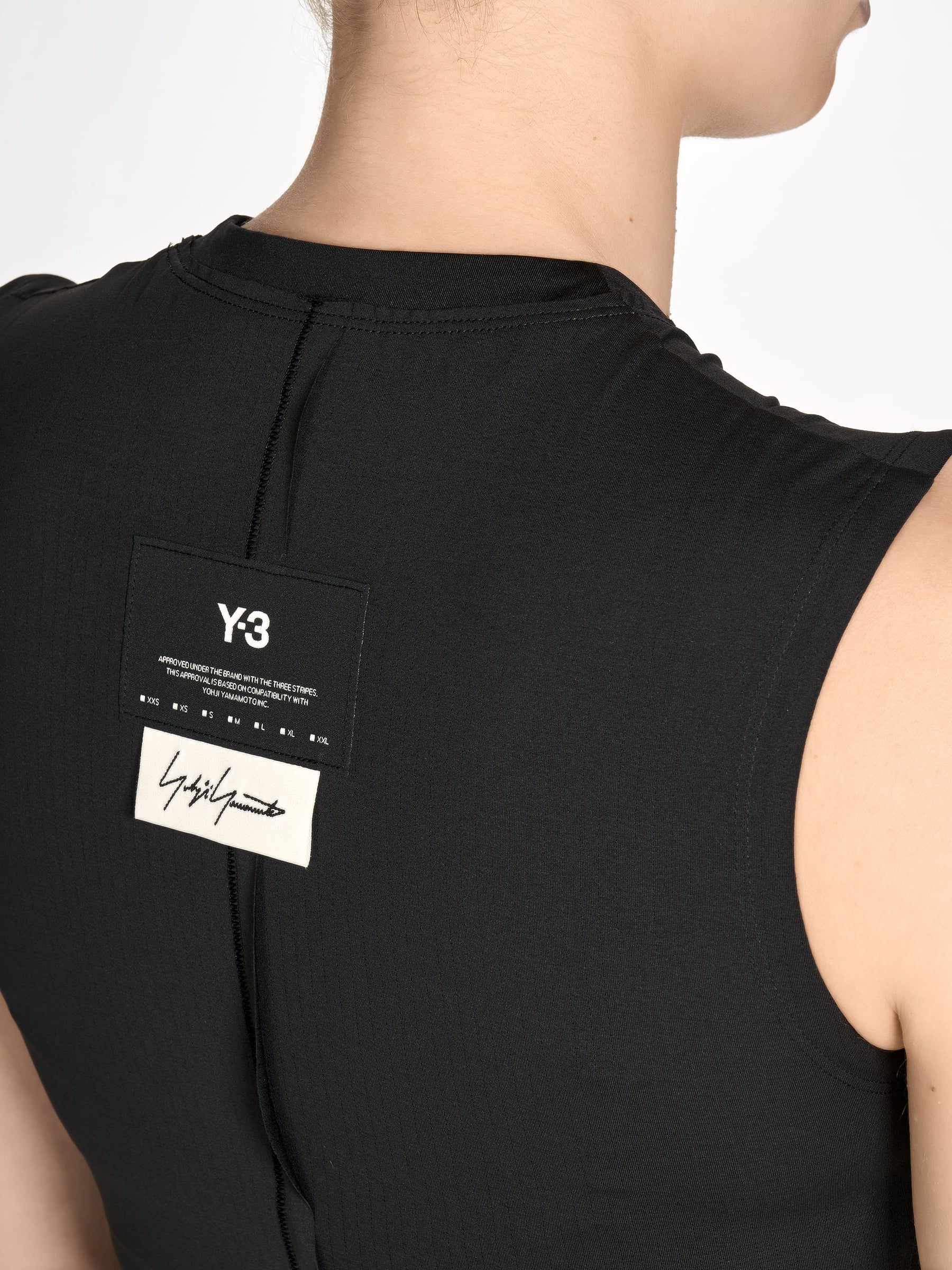 Close-up of the front of the Y-3 Women’s Knit Double-Dye Tank in Beige on a model, emphasizing the asymmetric neckline and jersey fabric texture.