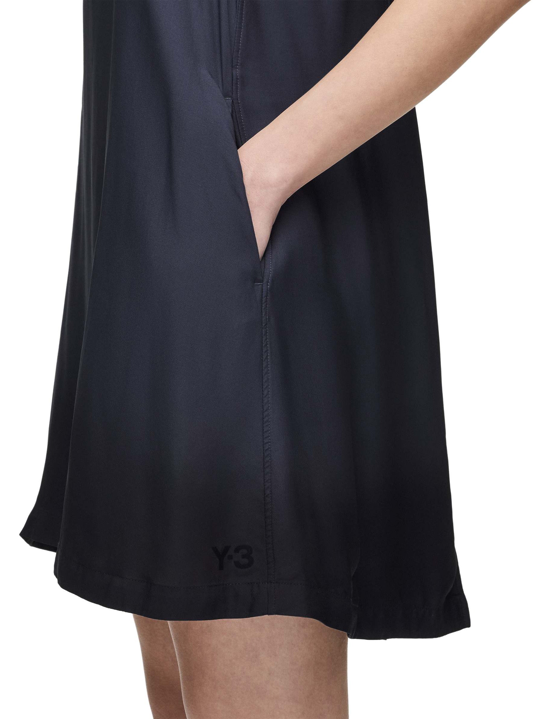 Side close-up of a female model wearing the Women’s Shirt Double-Dye Dress in night grey and black from Y-3, highlighting the loose fit and smooth plain-weave construction.