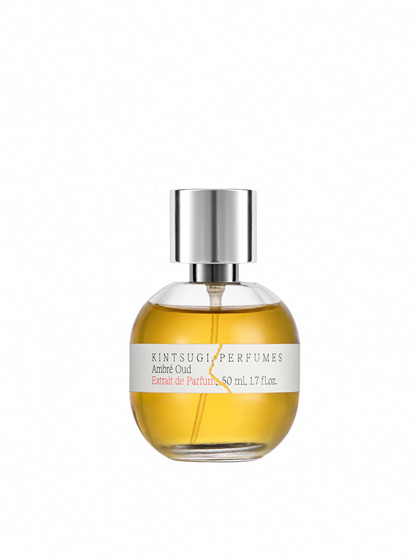 Kintsugi Perfumes Ambré Oud Extrait de Parfum - product shot showing round glass bottle with golden amber fragrance, silver cap and branded label on white background