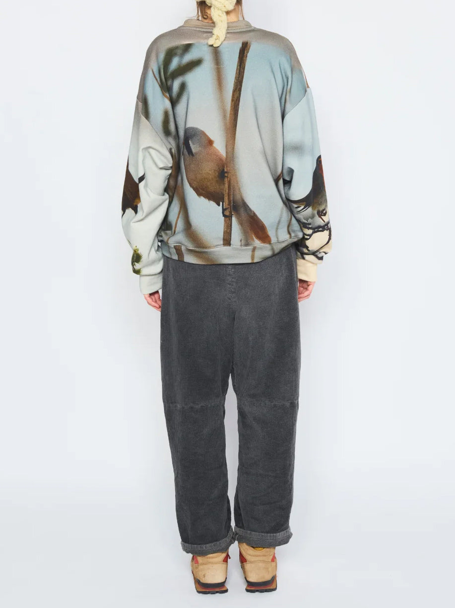 Anntian Unisex Sweater in Print A worn on model from the back, showing the continuation of the photographic bird print.