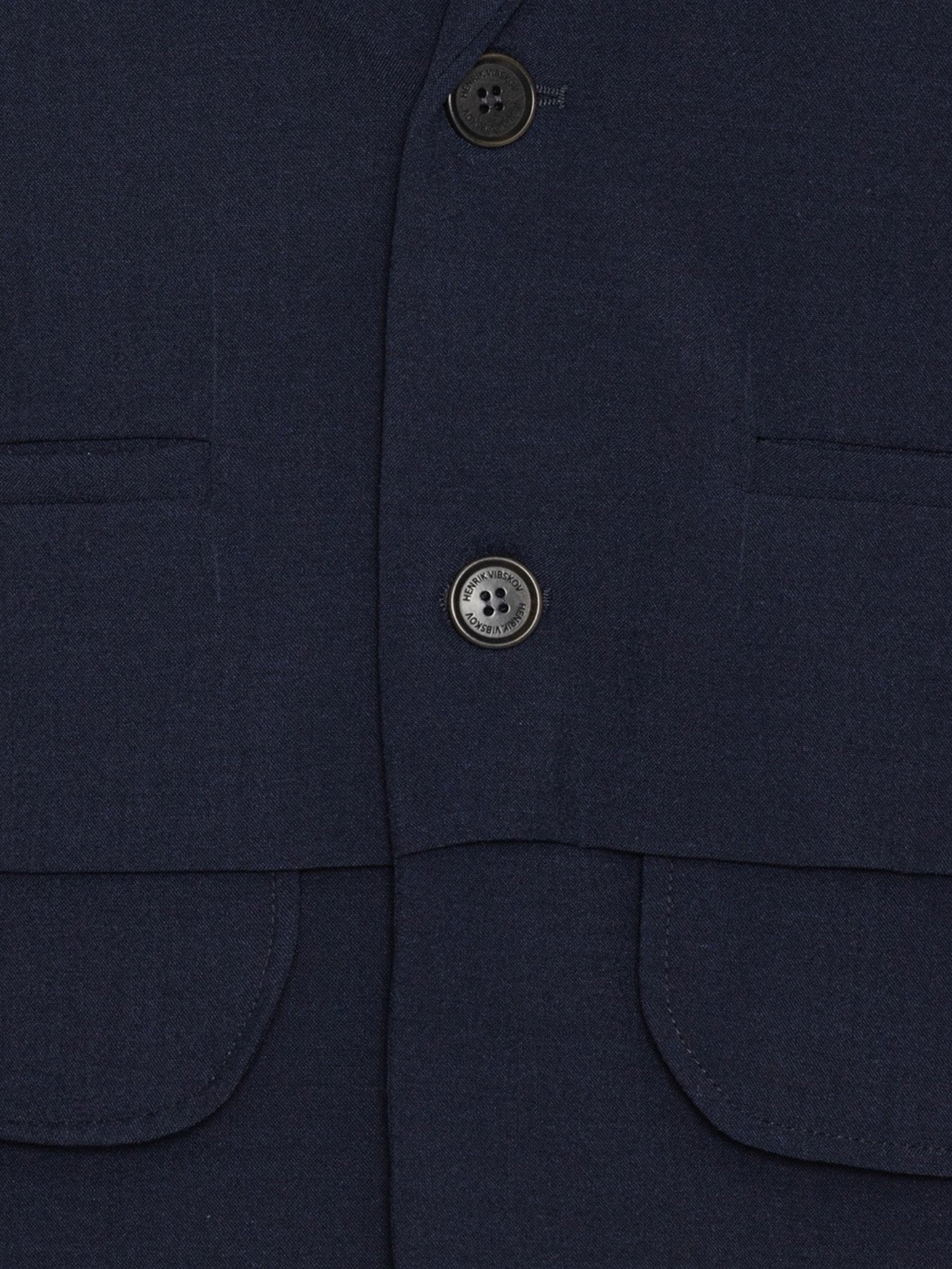 Close-up of Henrik Vibskov Ants Blazer in Dark Navy highlighting the fabric texture and front button fastening.