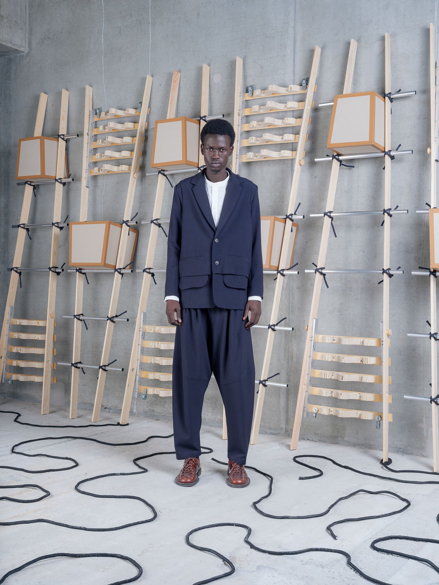 Henrik Vibskov Ants Blazer in Dark Navy worn with matching tailored trousers, front view.