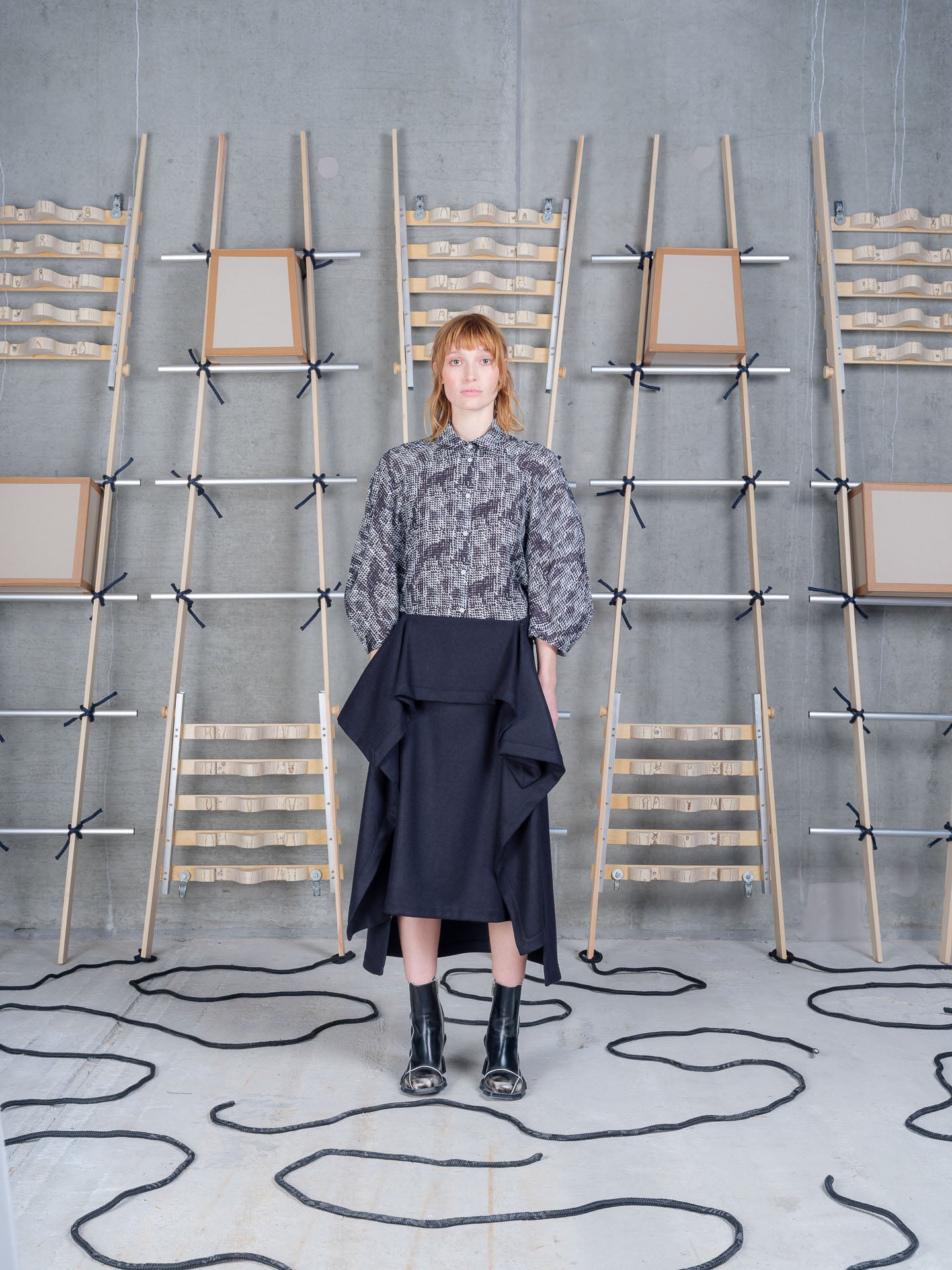 Model wearing Blanket Skirt in Blue Wool Checks by Henrik Vibskov front view with side drape detail