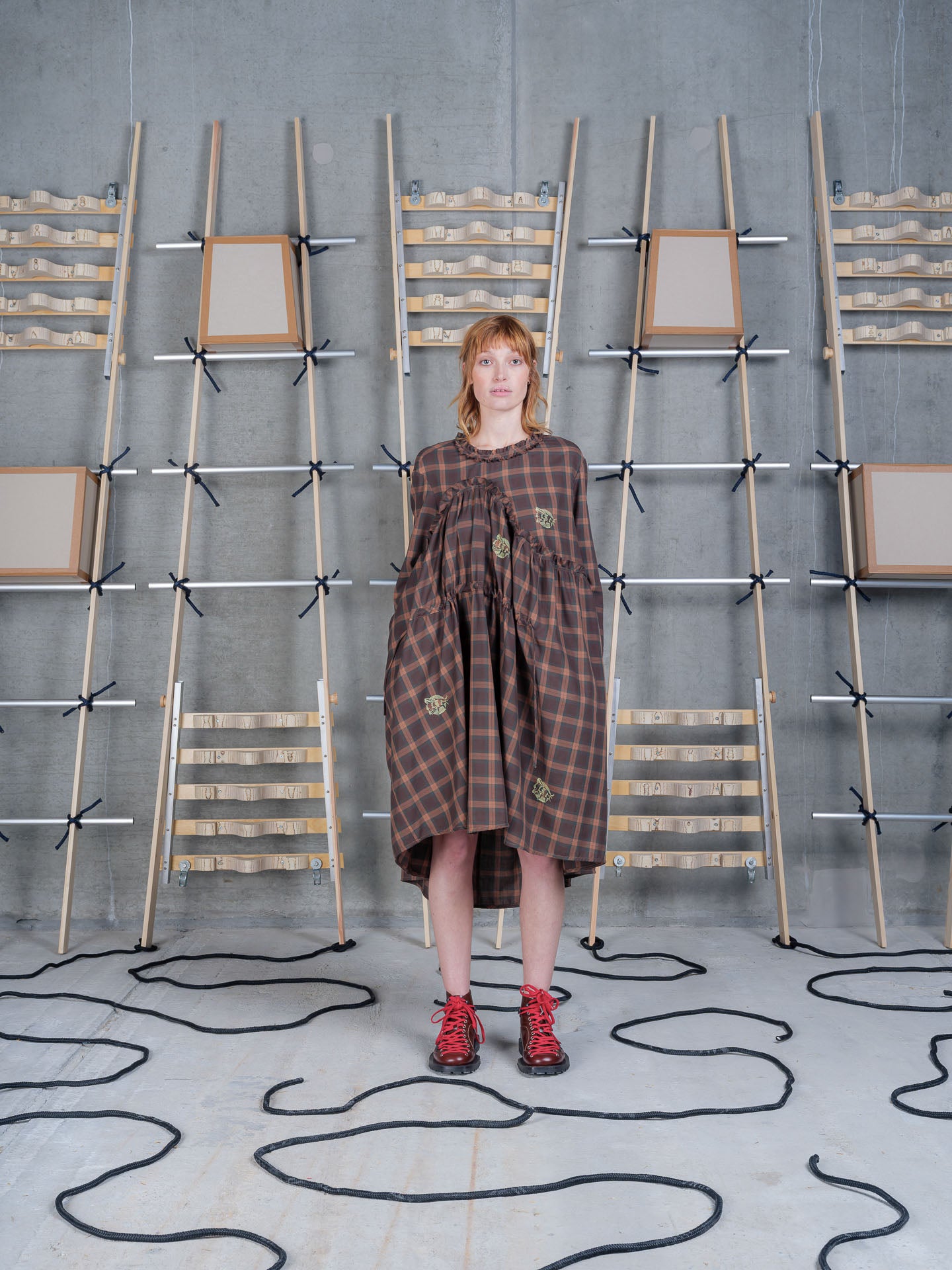 Three-quarter view of Henrik Vibskov Bon Chalant Dress LS in Brown Cotton Checks worn with the relaxed silhouette.