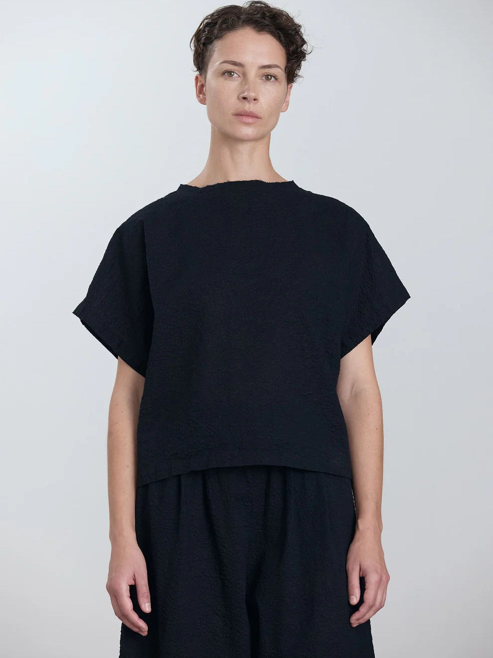 Black Crane Boxed Top in Midnight - front view on model showing crew neck detail and ripple textured fabric