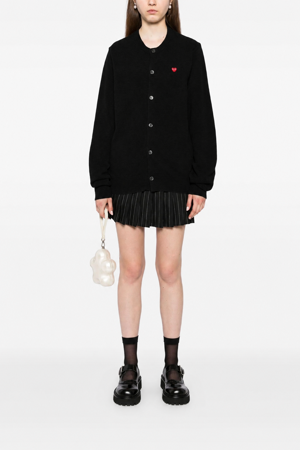 Female model wearing Comme des Garçons Play Unisex Cardigan Red Heart in black with classic button-up knit silhouette