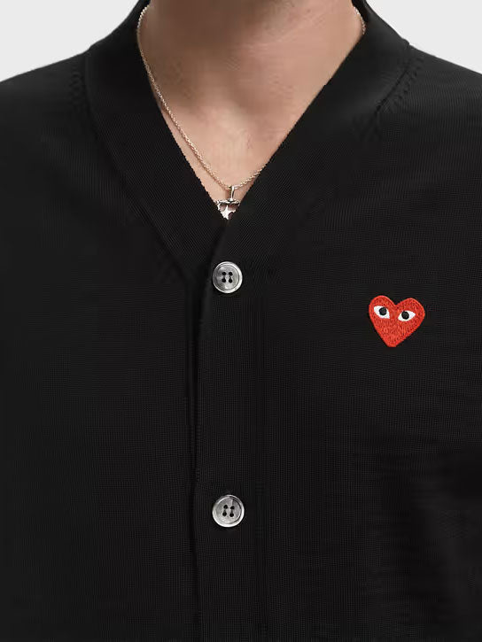 Close-up of the COMME des GARÇONS PLAY V-Neck Knit Cardigan Red Heart in Black, showing the V-neckline, buttons and embroidered heart logo.