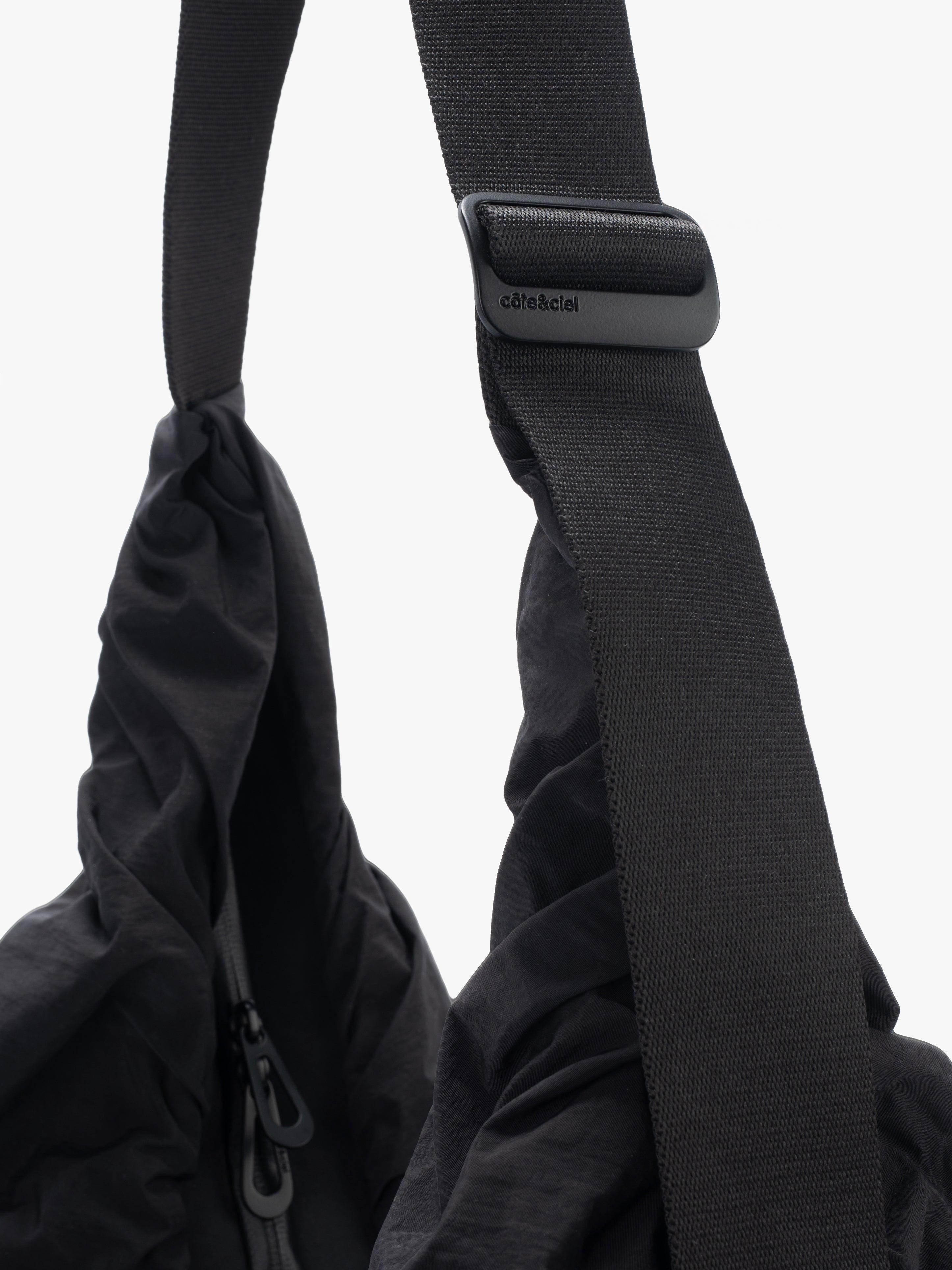 Closeup of Côte&Ciel Hyco S Otra Gathered crossbody bag in black, focusing on ergonomic strap design and ring clip for accessories.