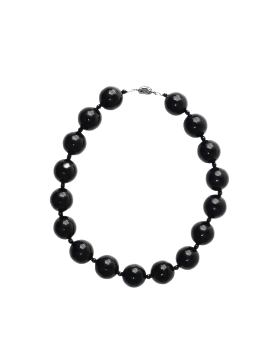 Black and round obsidian necklace with silver clasp from De Silang on a white background