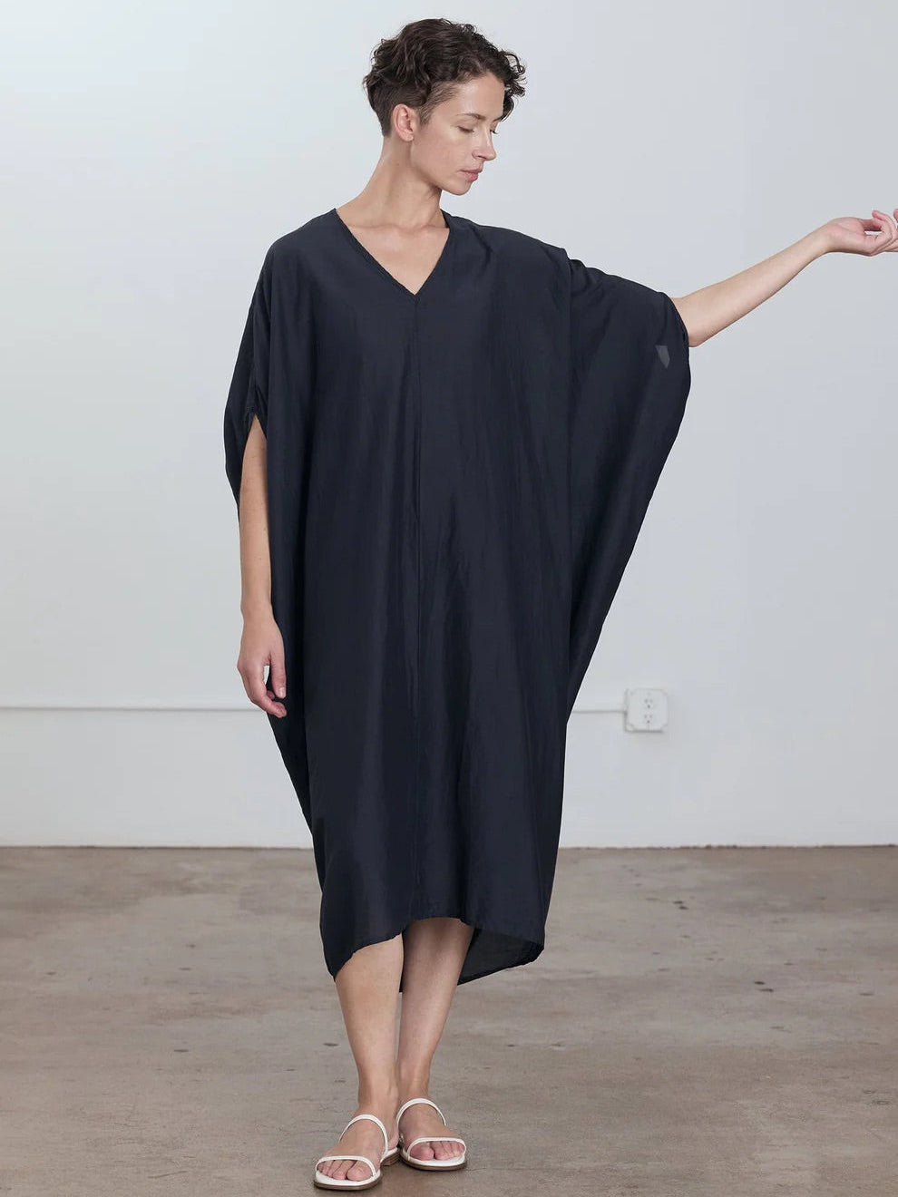Black Crane Draped Dress in Faded Black - front view on model showing v-neck outbinding and oversized silhouette