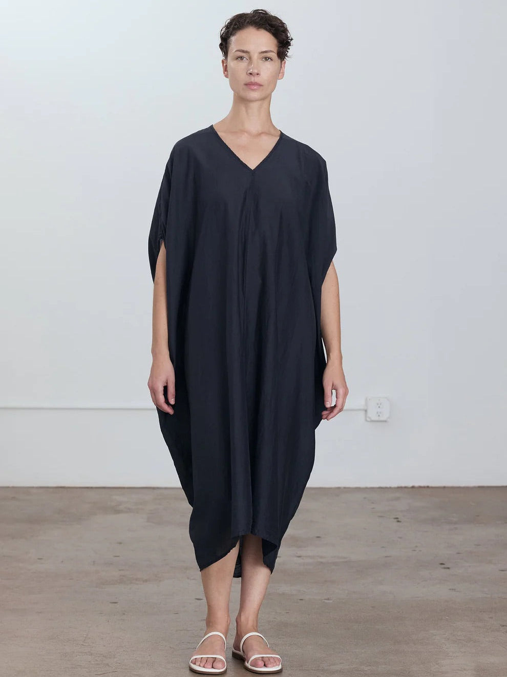 Black Crane Draped Dress in Faded Black - front view on model showing v-neck detail and center seam