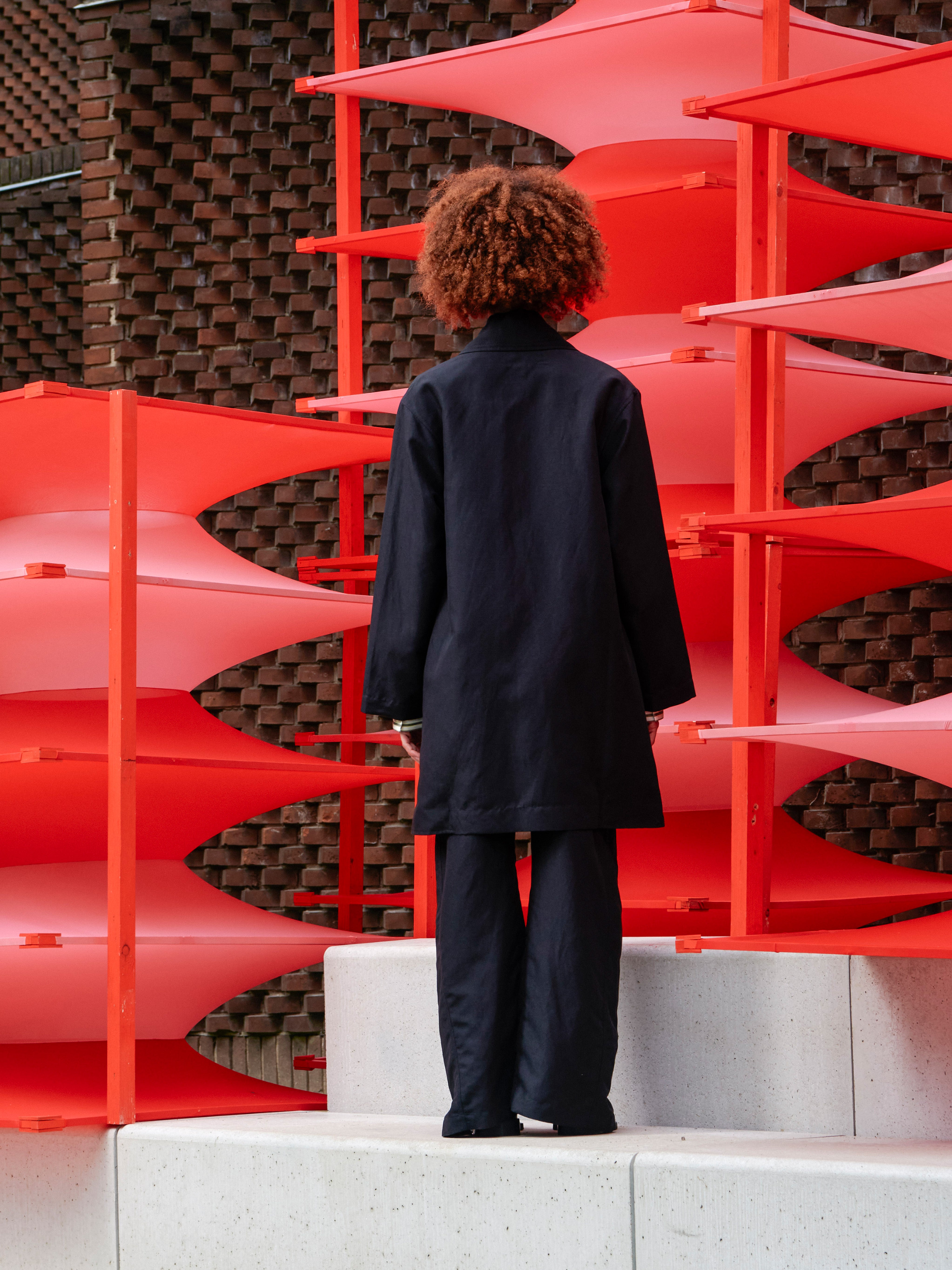 Back view of a model wearing the Beetle Coat, showing the layered back design and relaxed fit.