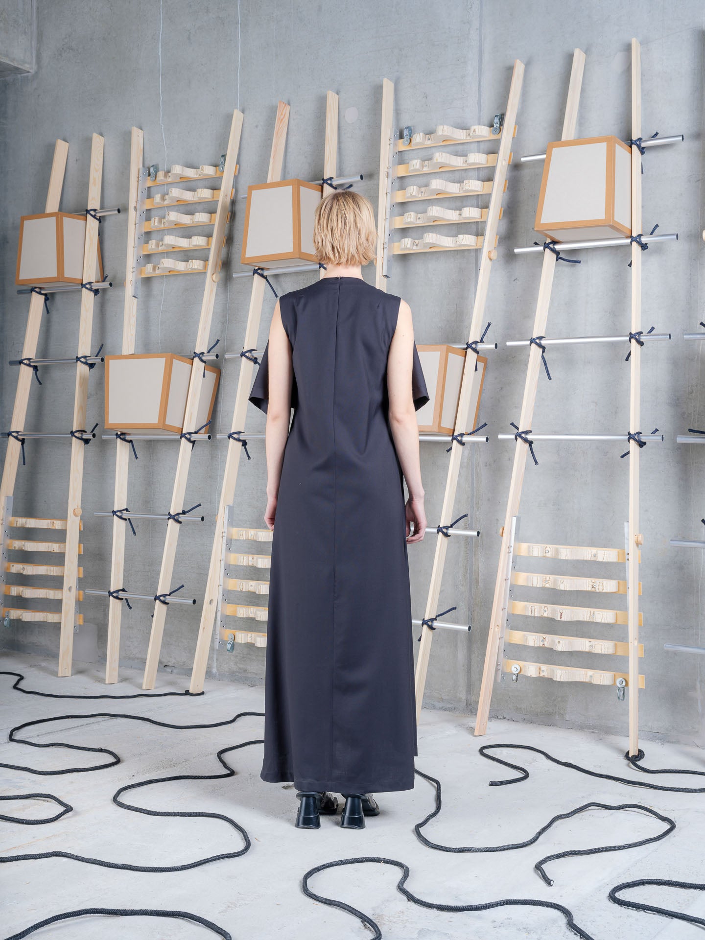 Model wearing the Henrik Vibskov Blanket Dress in black, back view