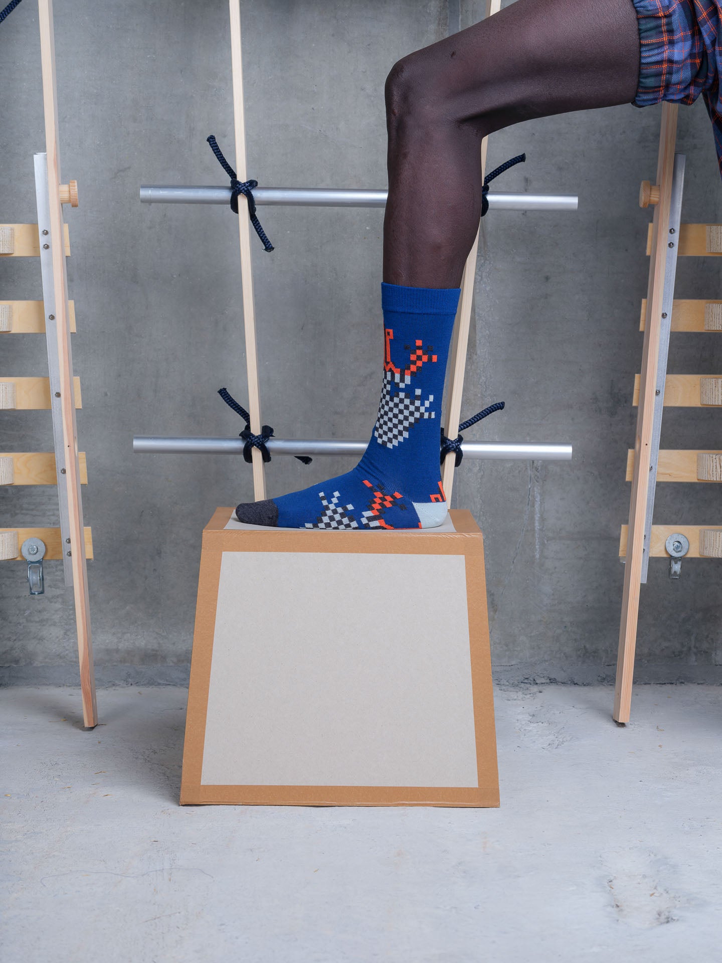 Henrik Vibskov mid-calf wool blend sock in pixelated blue frog with black and white checkerboard graphic and orange details