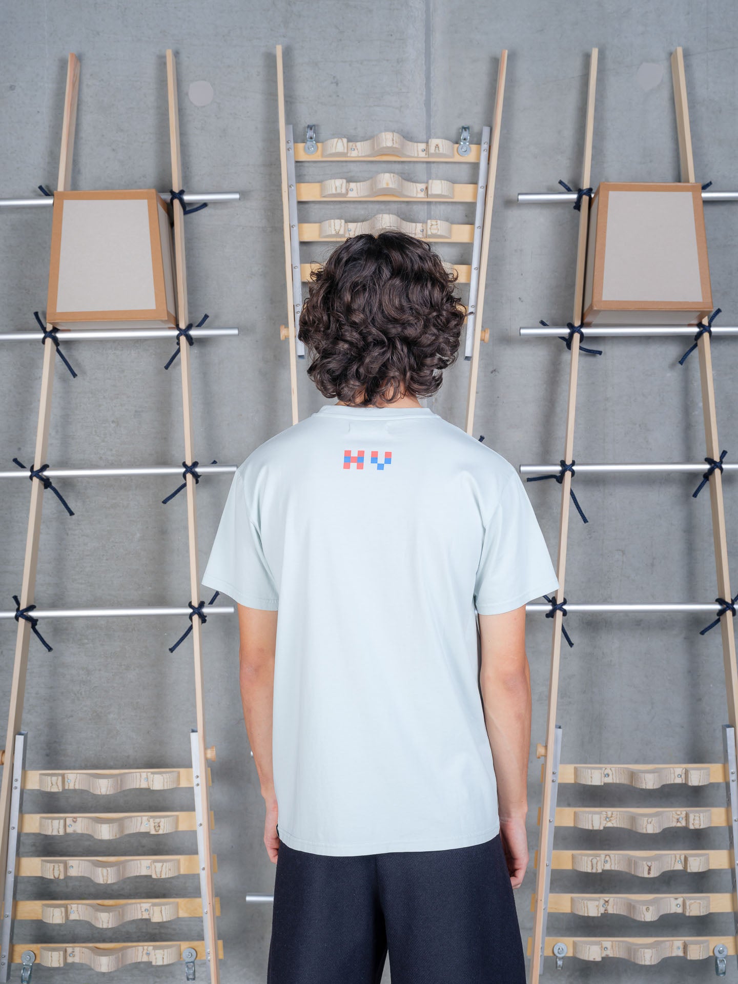 Henrik Vibskov Cross Stitch Tee in Sky Grey on-model back view, pale sky grey organic cotton, relaxed fit, crew neck