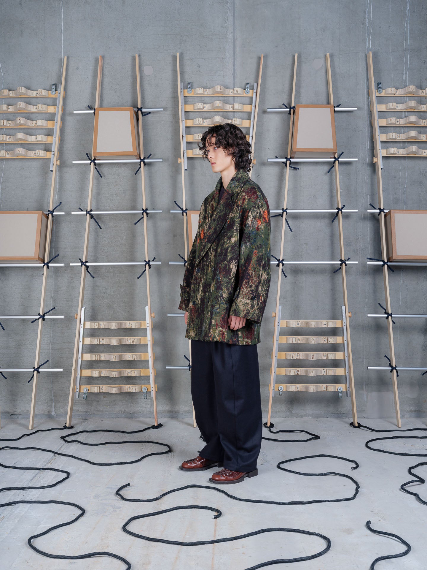 Henrik Vibskov Dimout Coat in Gobelin Swamp worn on model, full-length front view, jacquard tapestry print, double-breasted fastening, notched lapel, oversized fit