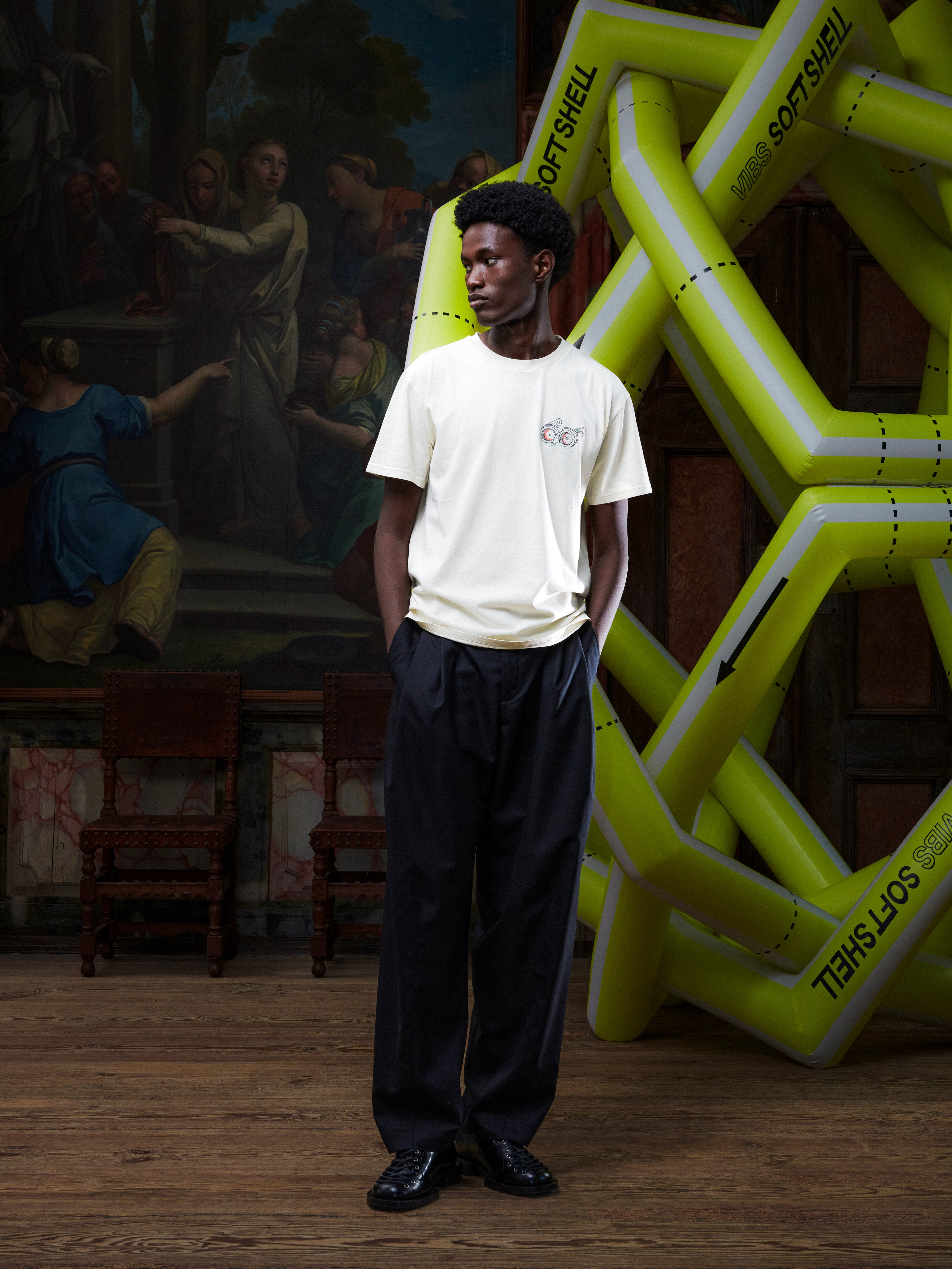 Model wearing the Henrik Vibskov Eyeballin T in Bone White, front view. The model is 191 cm and wears size M, showing the round neck, short sleeves, square fit, and eyeball illustration.