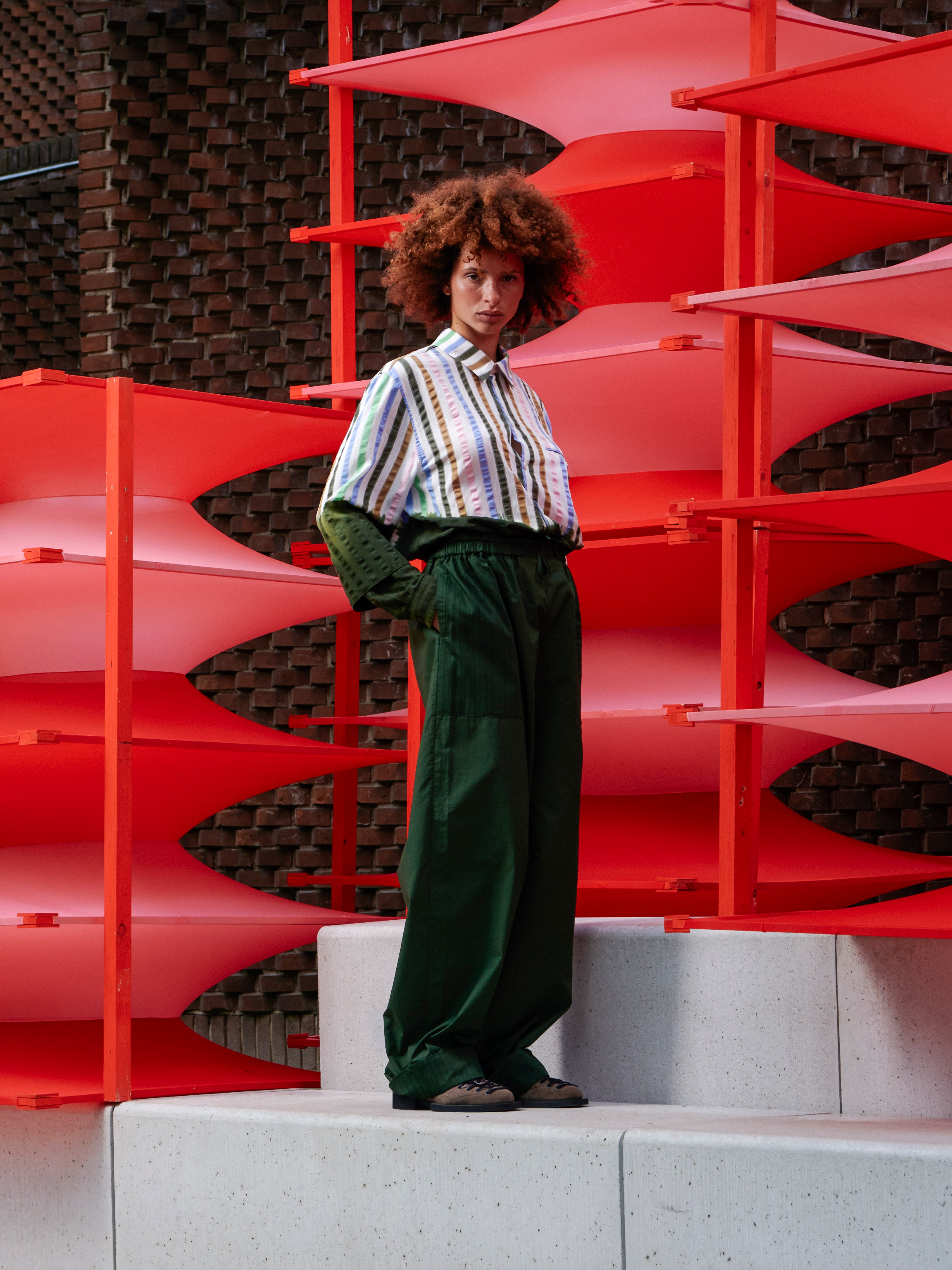Model wearing the Helmet Pants in Garden Green navy green wide-leg pants with airy sculptural silhouette, side view – Henrik Vibskov Spring/Summer 2026 Key Collection
