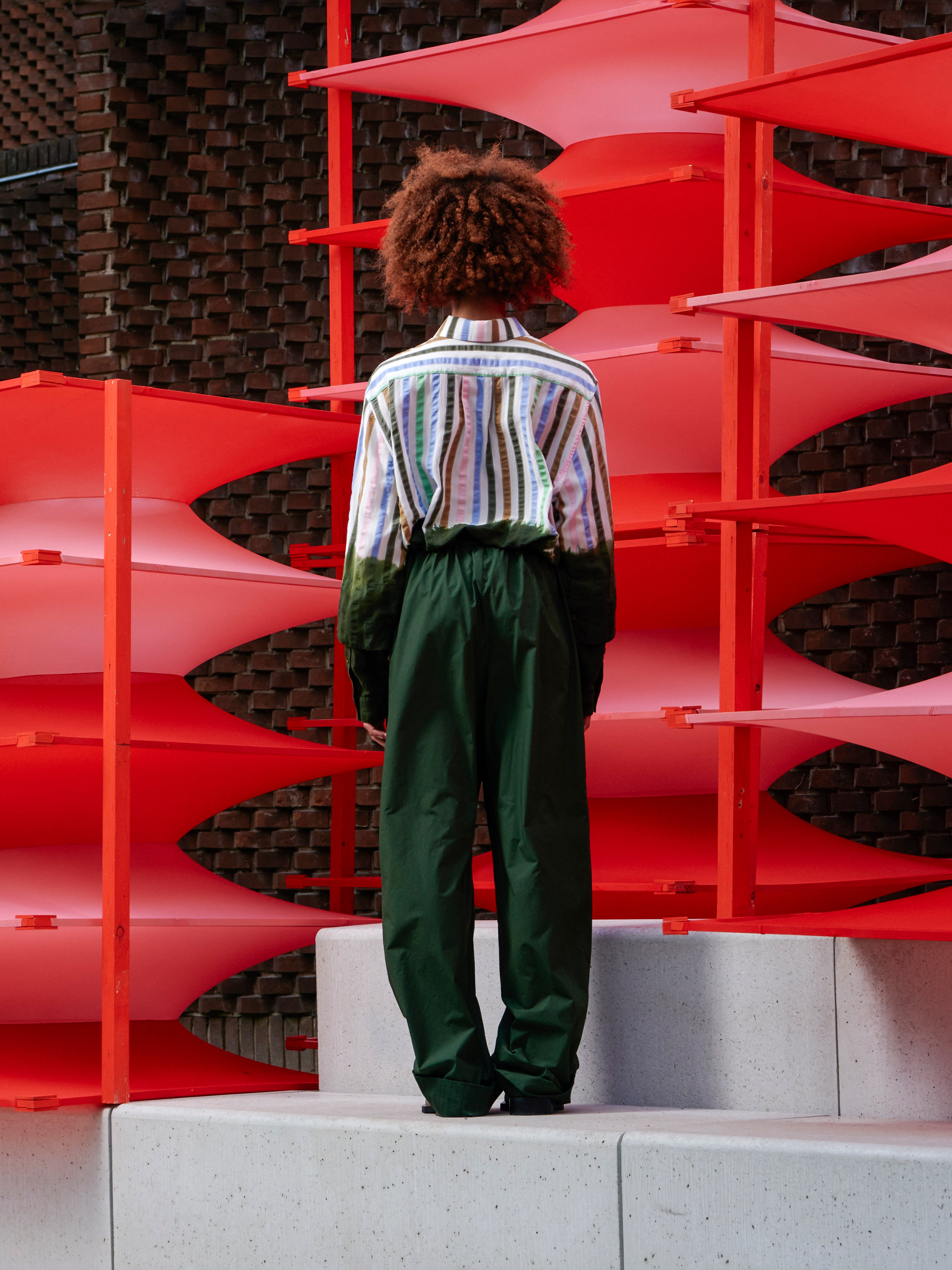 Model wearing the Helmet Pants in Garden Green navy green wide-leg pants with side pockets and relaxed silhouette, back view – Henrik Vibskov Spring/Summer 2026 Key Collection