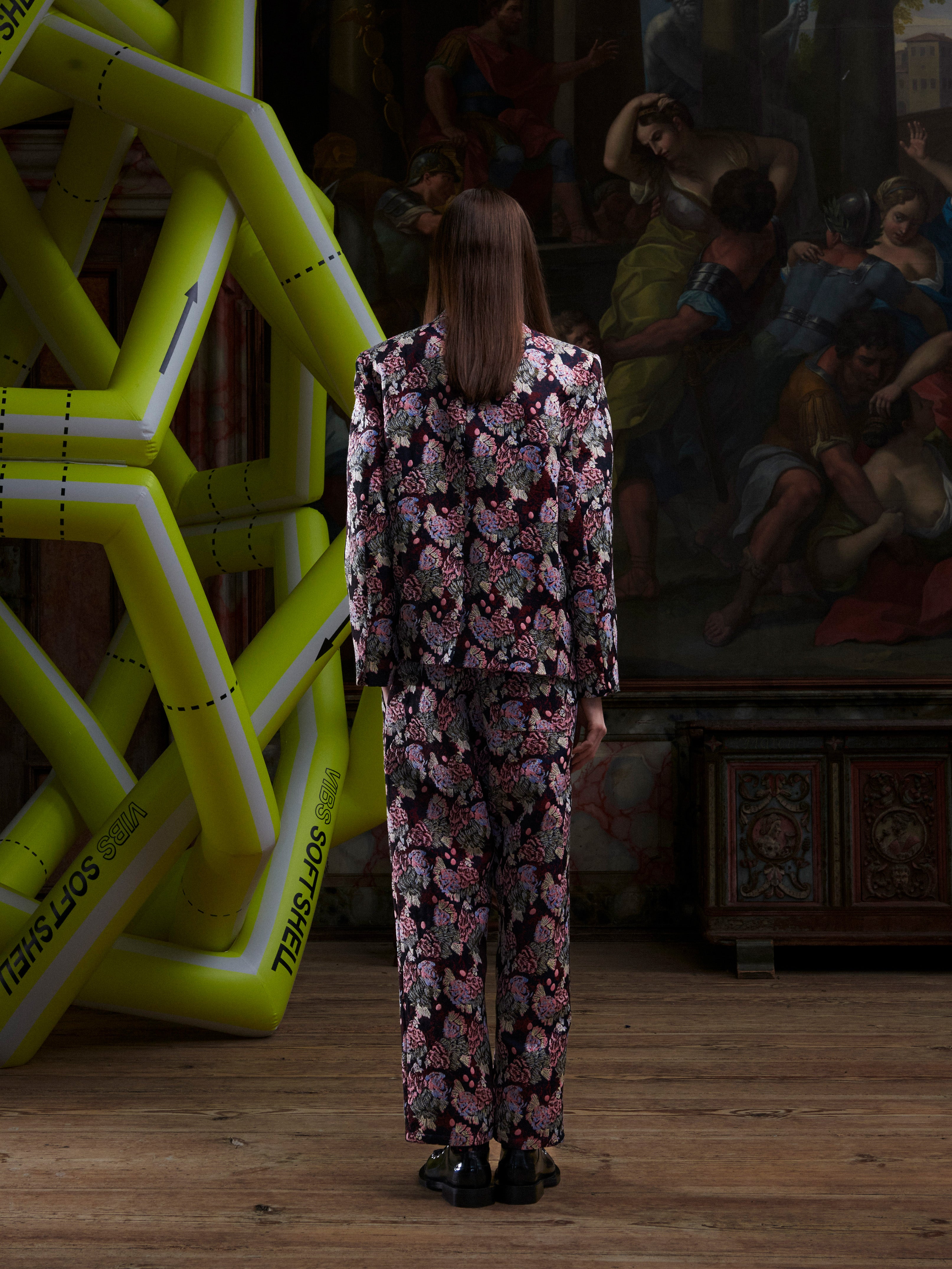 Female model wearing the Henrik Vibskov Motif Blazer in Navy Chickens, back view, showing the abstract chicken embroidery across the back of the blazer.