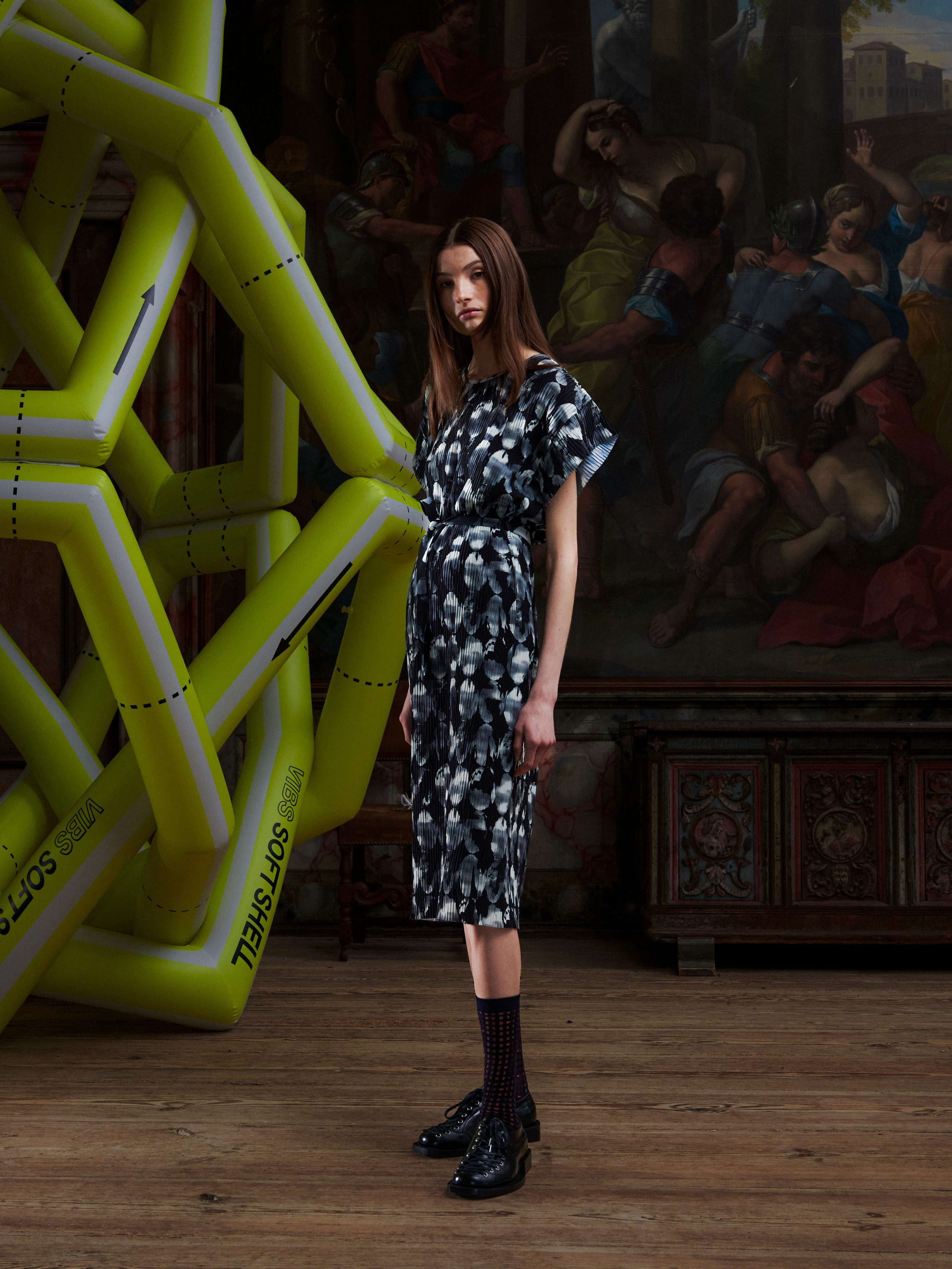 Model wearing the Henrik Vibskov New Pina Plissé Dress in Bursting Eggs, side view, showing the plissé texture, waist tie, and straight silhouette.