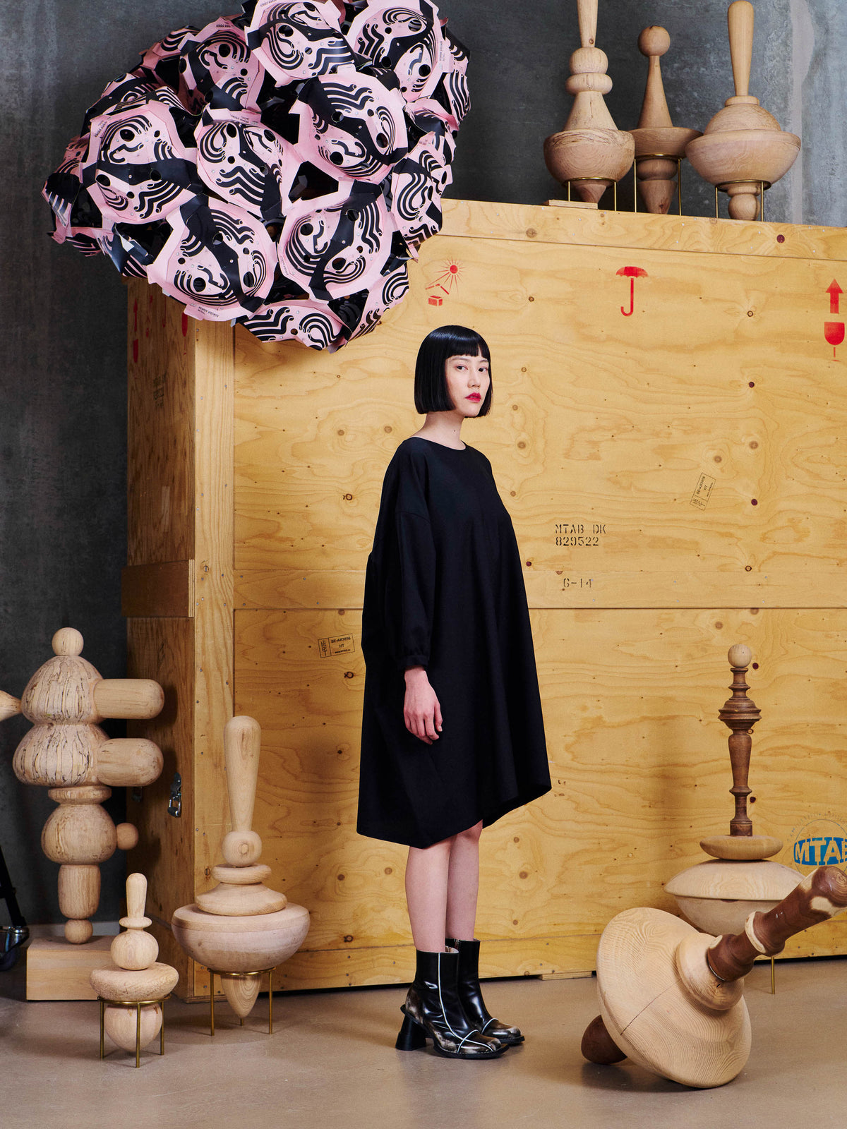Henrik Vibskov Non Chalant Dress in Black worn side view, showing the voluminous shape, dropped shoulders and slightly curved hem.