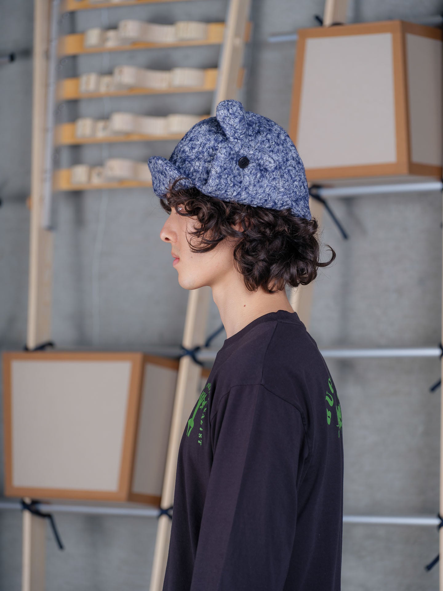 Side view of Henrik Vibskov Pilot Frog Hat in blue pebbles showing folded side flaps, panel seams and padded details
