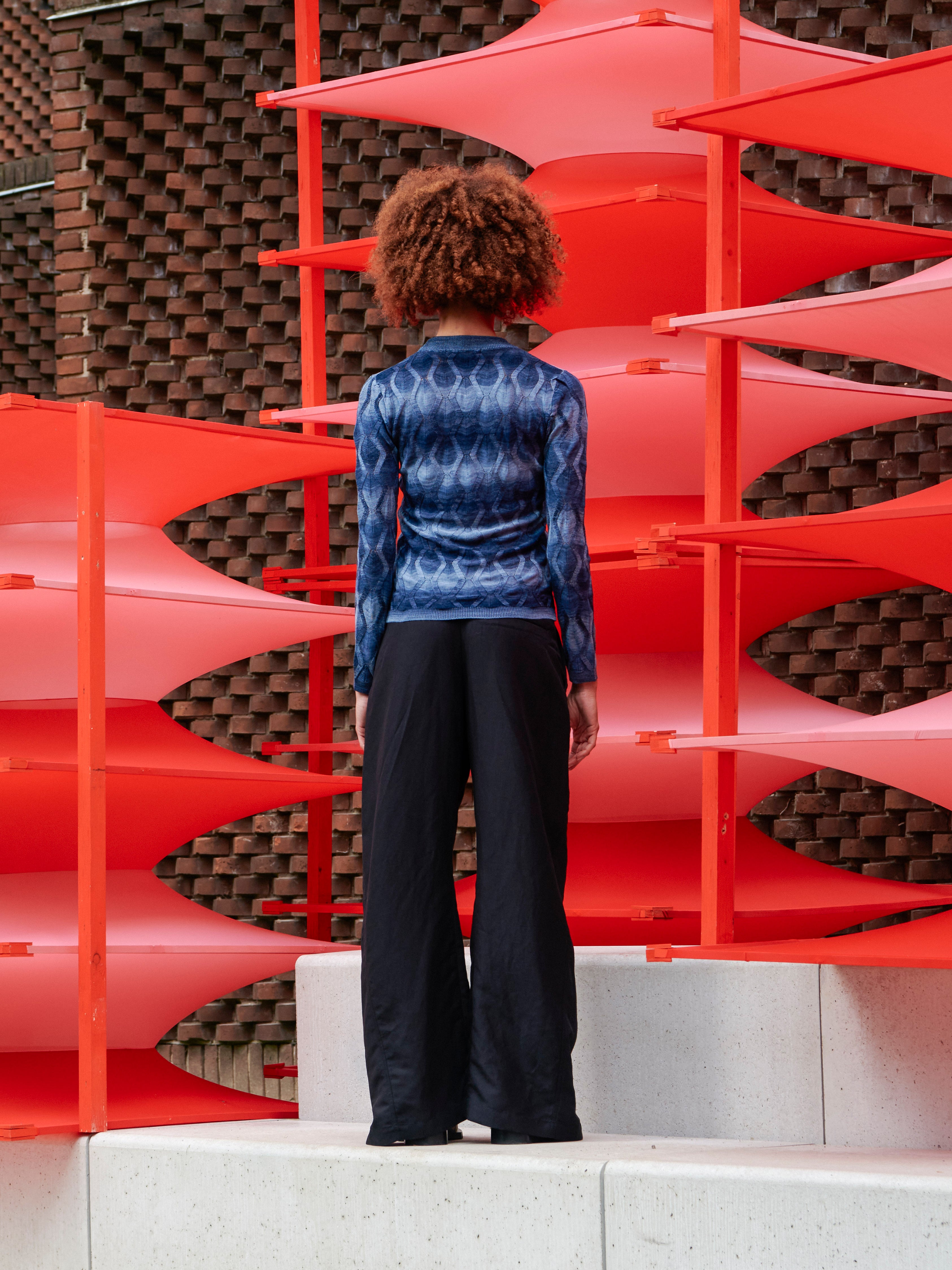 Model wearing the Resonance Longsleeve in Navy Flame blue patterned long sleeve top with ribbed hems and form-fitting silhouette, back view – Henrik Vibskov Spring/Summer 2026 Key Collection