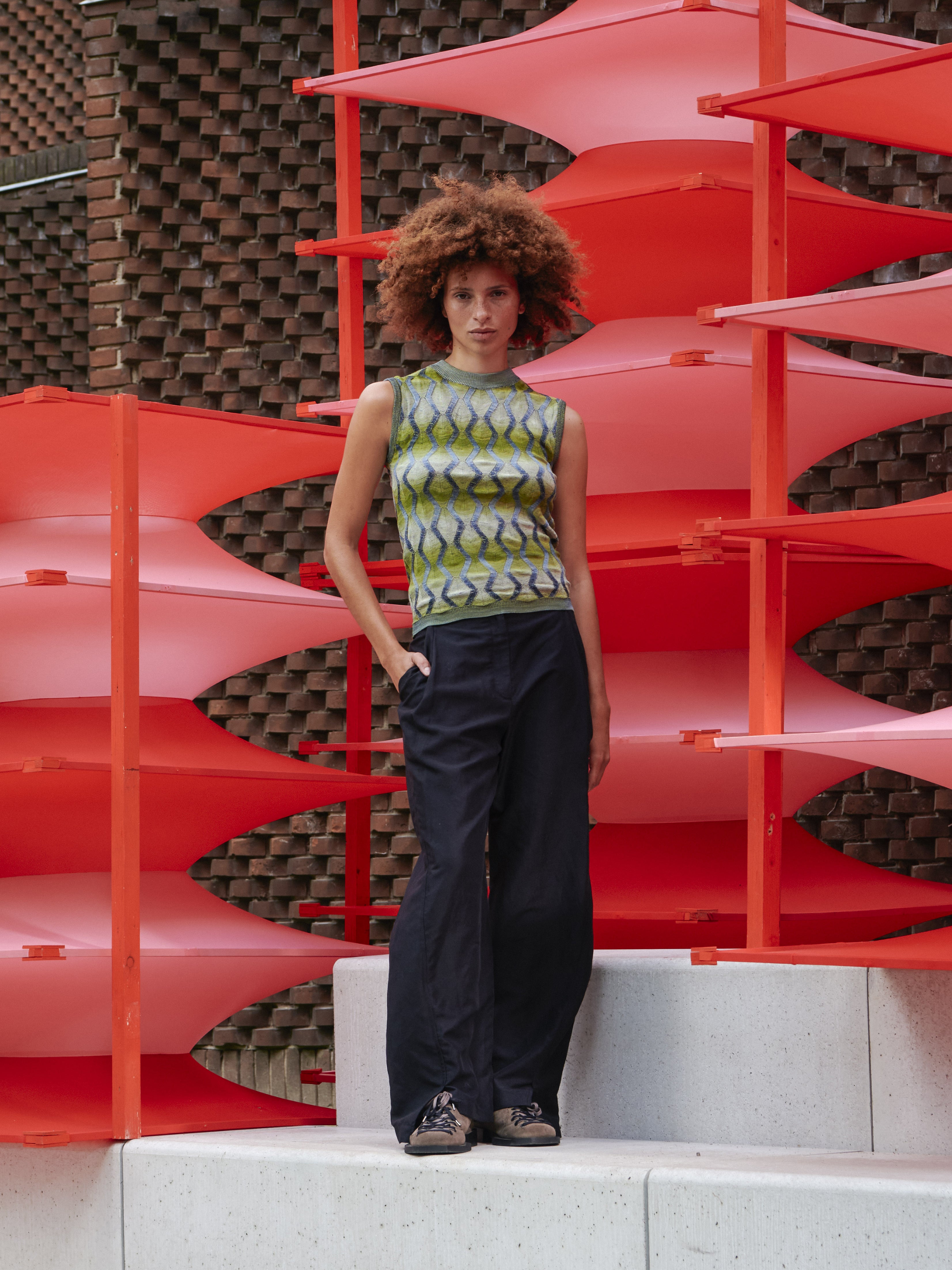 Model wearing Henrik Vibskov Resonance Top in Multi Flame, front view, sleeveless fitted top with green and silver pattern, snug round neck, and ribbed hems.