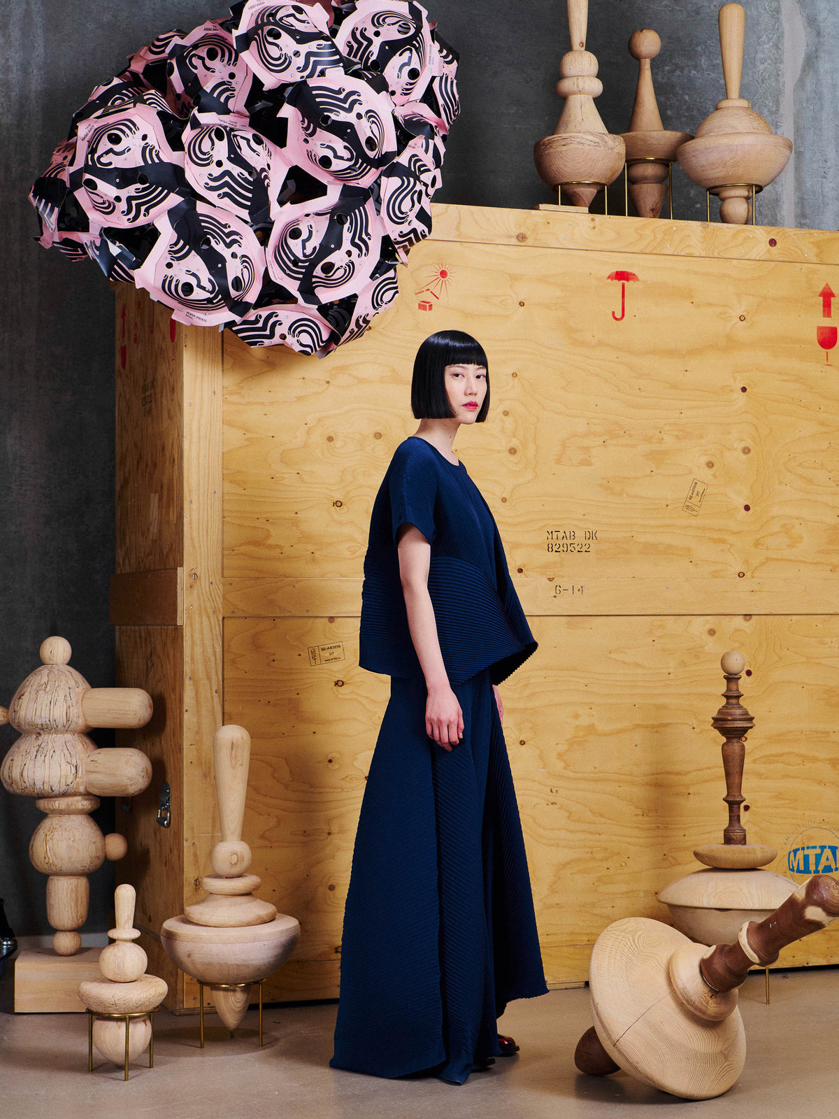 Side view of female model wearing Henrik Vibskov Thumb Plisse Blouse in Dress Blues, showing the sculptural drape and volume through the sides.
