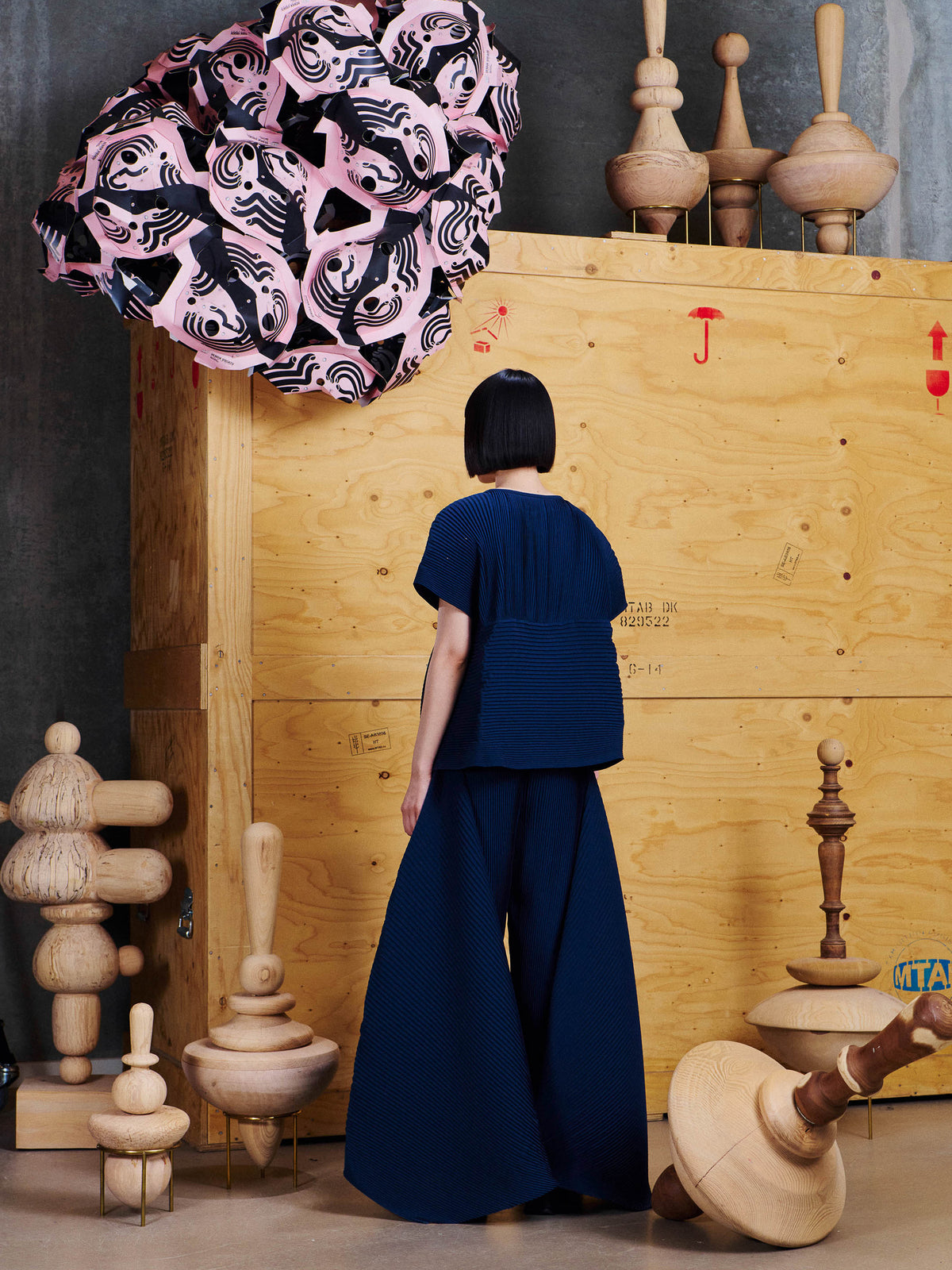 Back view of female model wearing Henrik Vibskov Thumb Plisse Blouse in Dress Blues, showing the pleated texture and structured horizontal panel across the back.