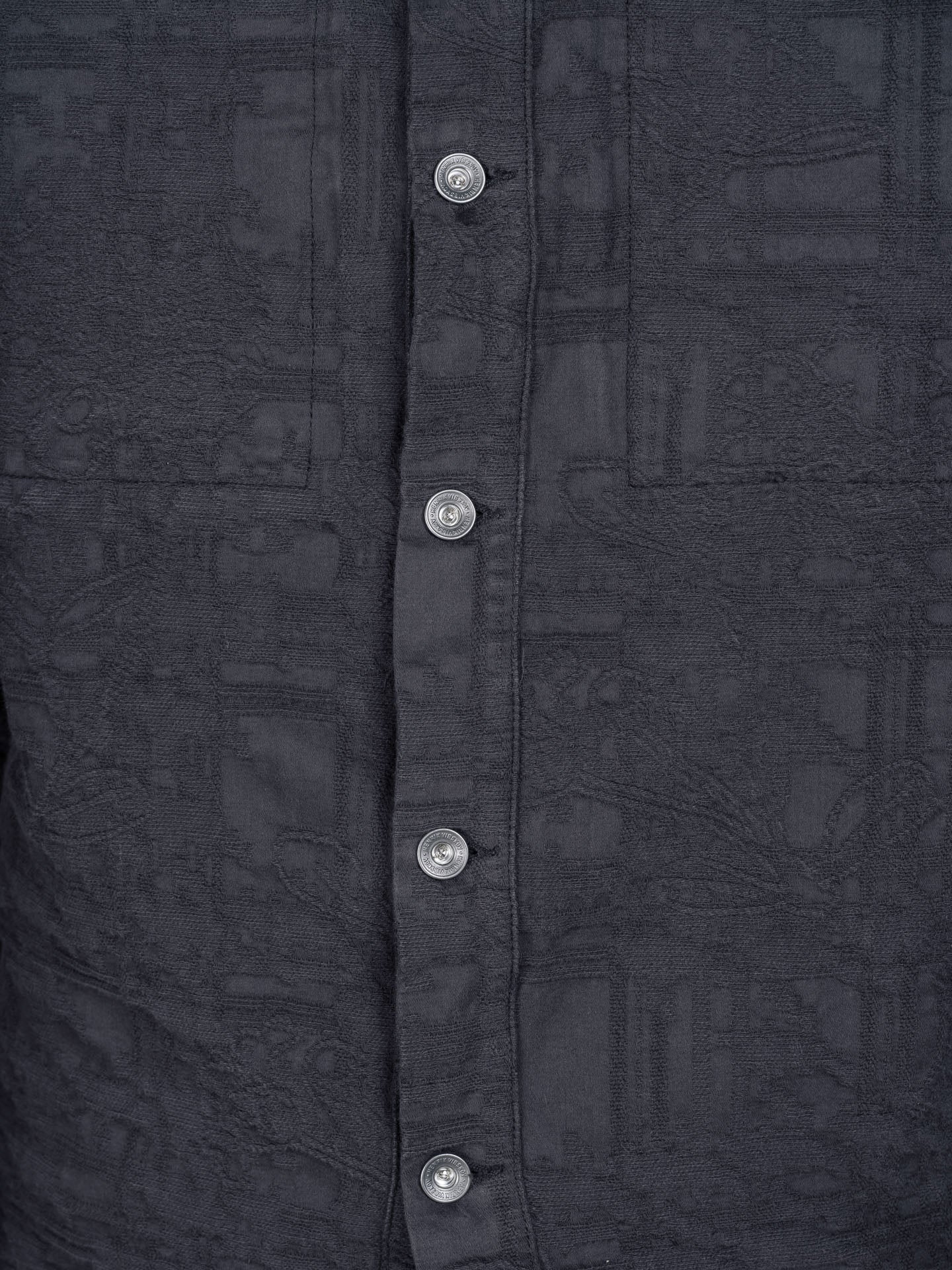 Henrik Vibskov Toadally Denim Jacket in Black, close-up of tonal jacquard woven pattern, silver press-stud detail