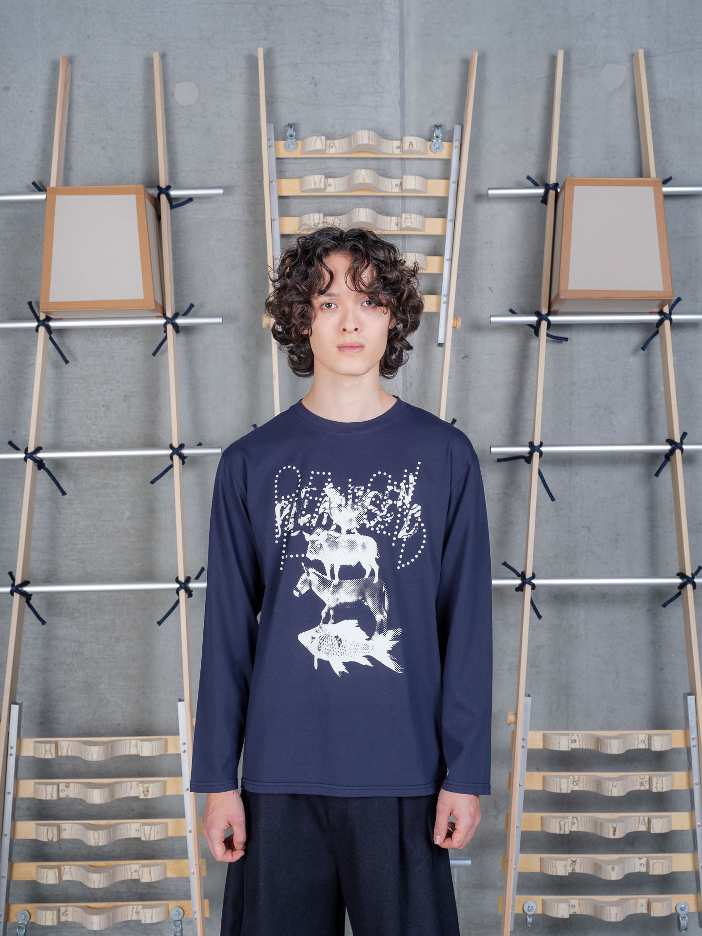 Front view of a male model wearing the Henrik Vibskov Tower Swamp Blouse in Black, showing the surreal stacked animal artwork, dotted lettering, and organic cotton long-sleeve design.