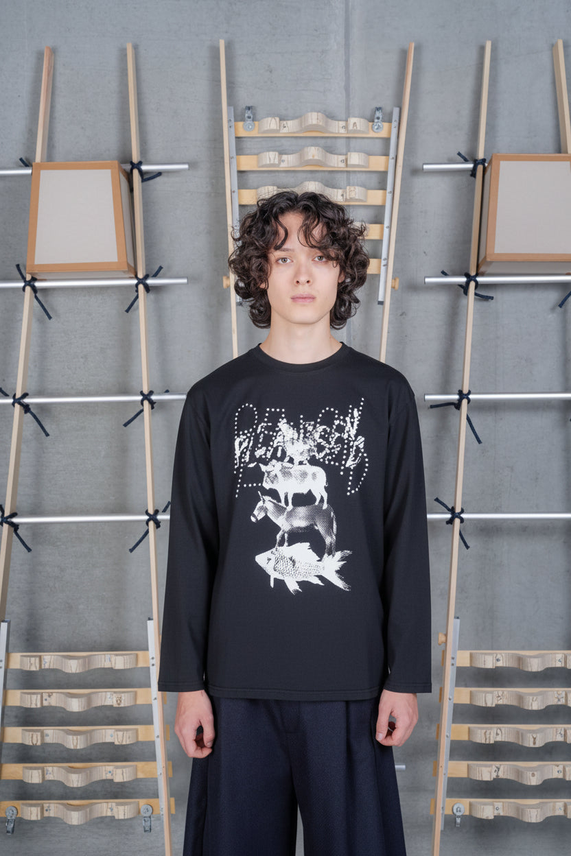 Front view of a male model wearing the Henrik Vibskov Tower Swamp Blouse in Black, showing the surreal stacked animal artwork, dotted lettering, and organic cotton long-sleeve design.