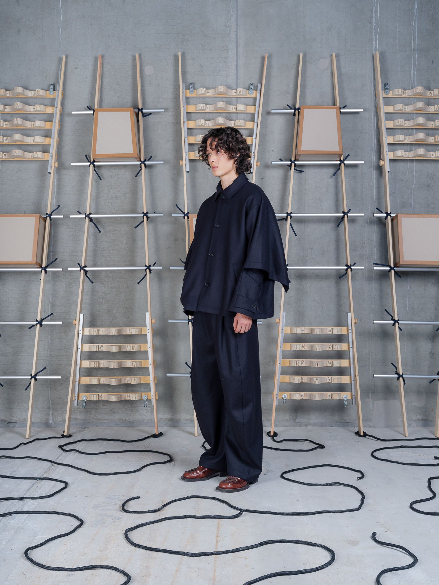 Henrik Vibskov Uncut Jacket Black, model side view, showing dropped shoulder and cape-like volume