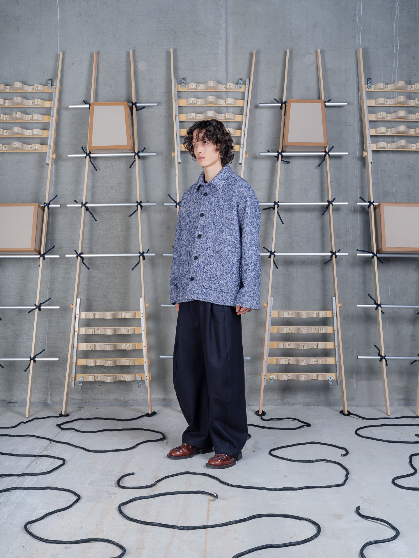 Henrik Vibskov Wheel Jacket in Blue Pebbles on-model side view, relaxed silhouette, point collar, patch pocket detail, styled with navy trousers