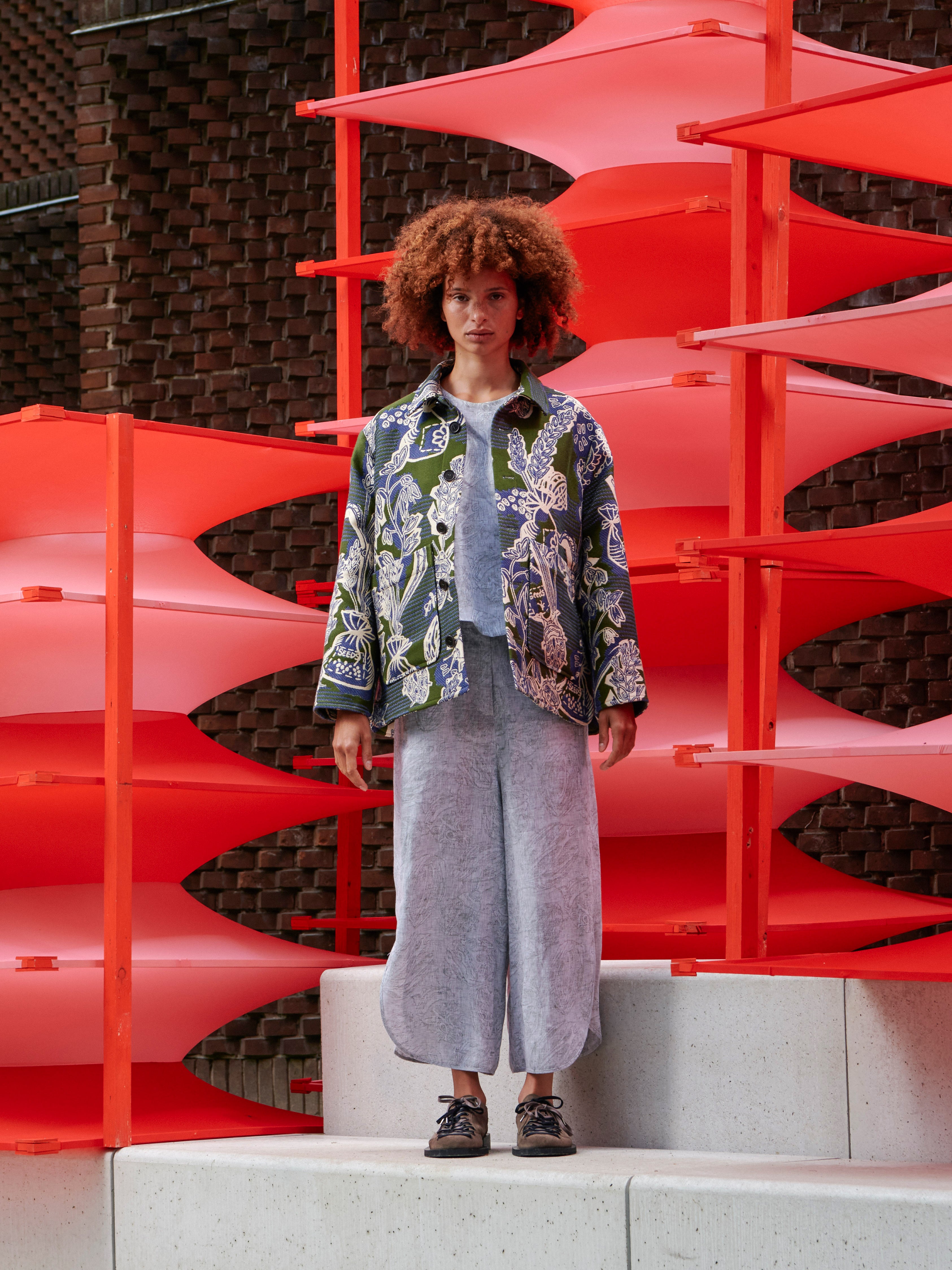 Model wearing the open Wheel Jacket in Garden of EEden green blue and white floral boxy jacket with patch pockets and straight hem, front view – Henrik Vibskov Spring/Summer 2026 Key Collection